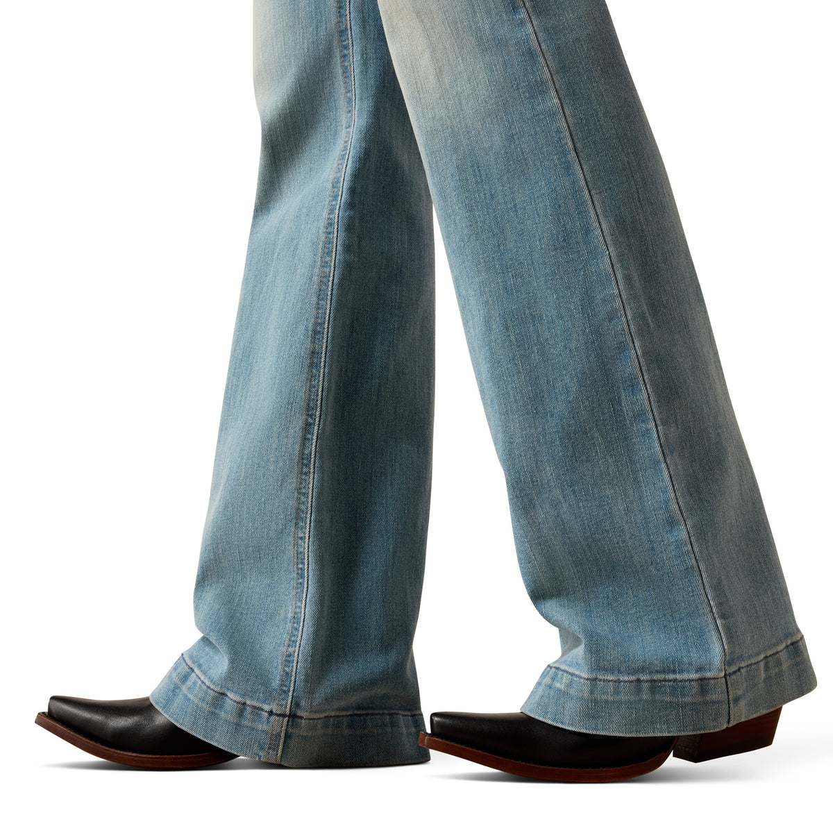 Close-up of blue jeans and black shoes on a white background