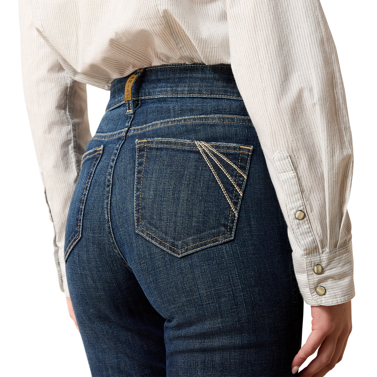 Person wearing blue jeans and a light-colored shirt on a white background