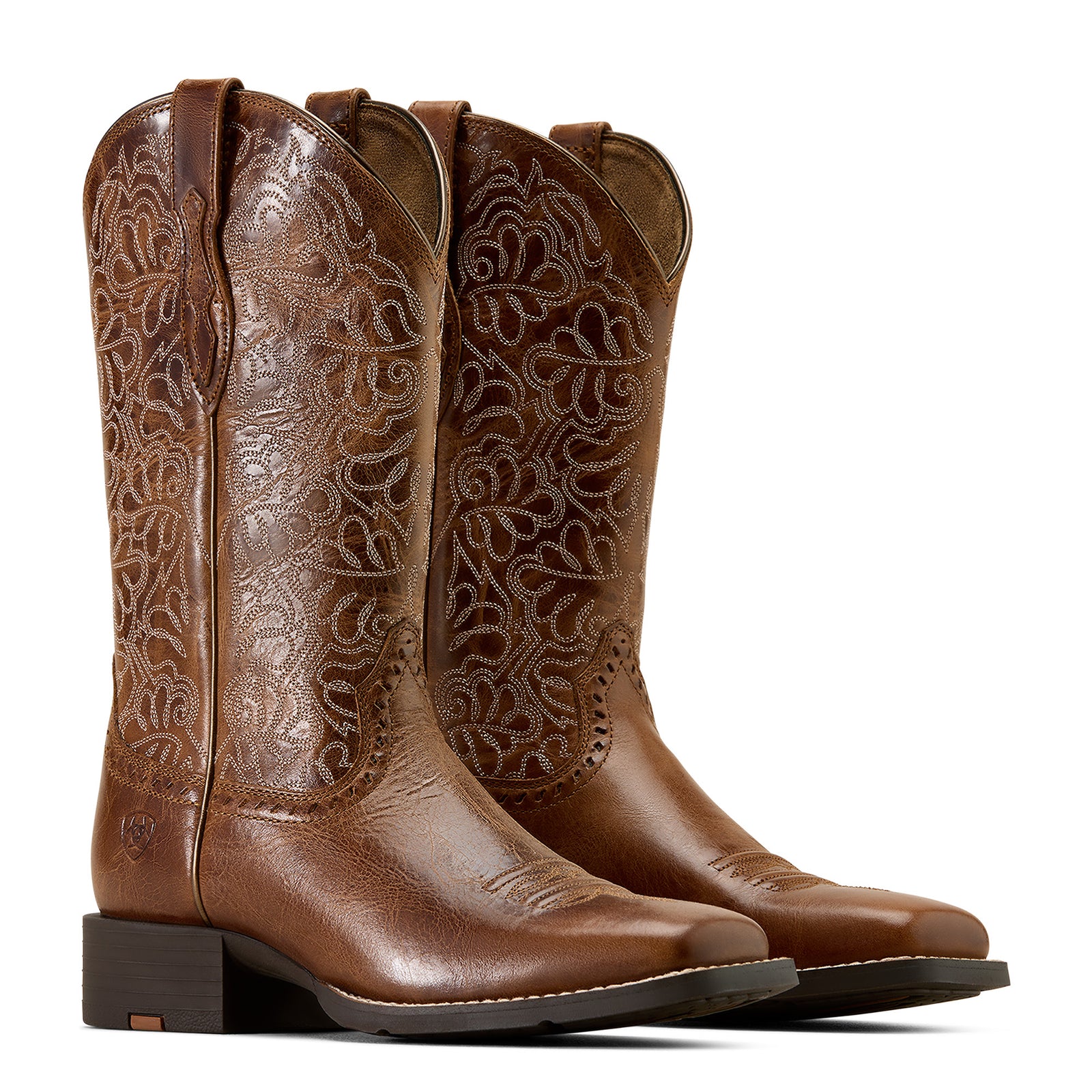 Pair of brown cowboy boots with intricate embossing on a white background