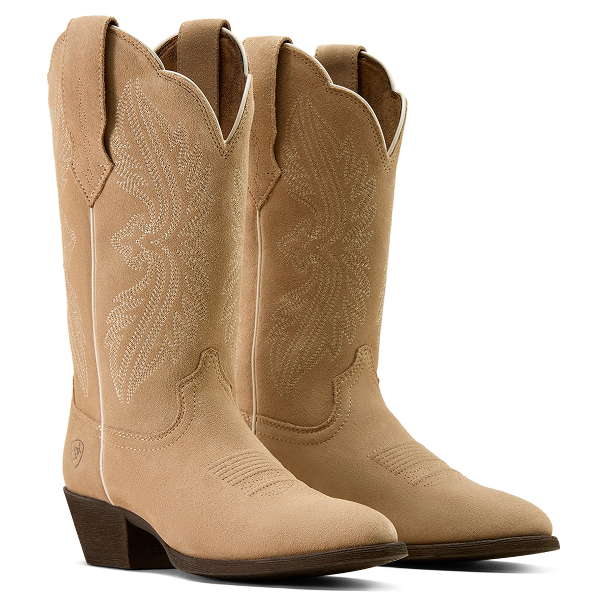 Pair of tan cowboy boots on a white background