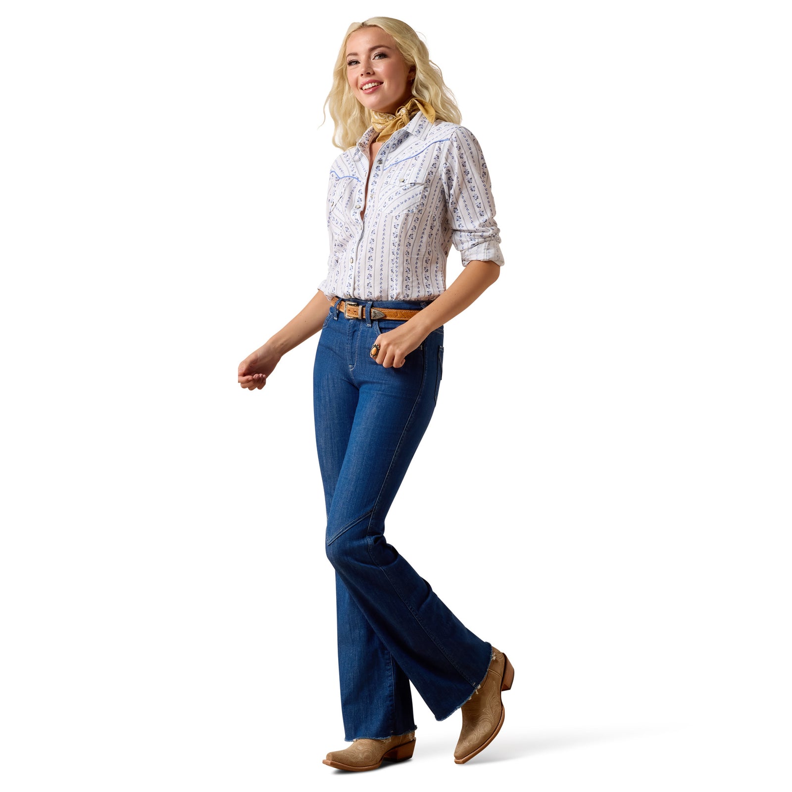 Woman wearing a white patterned shirt, blue jeans, and brown shoes on a white background