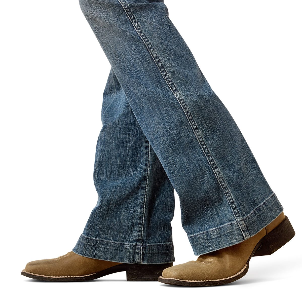 Blue jeans worn with brown shoes on a white background