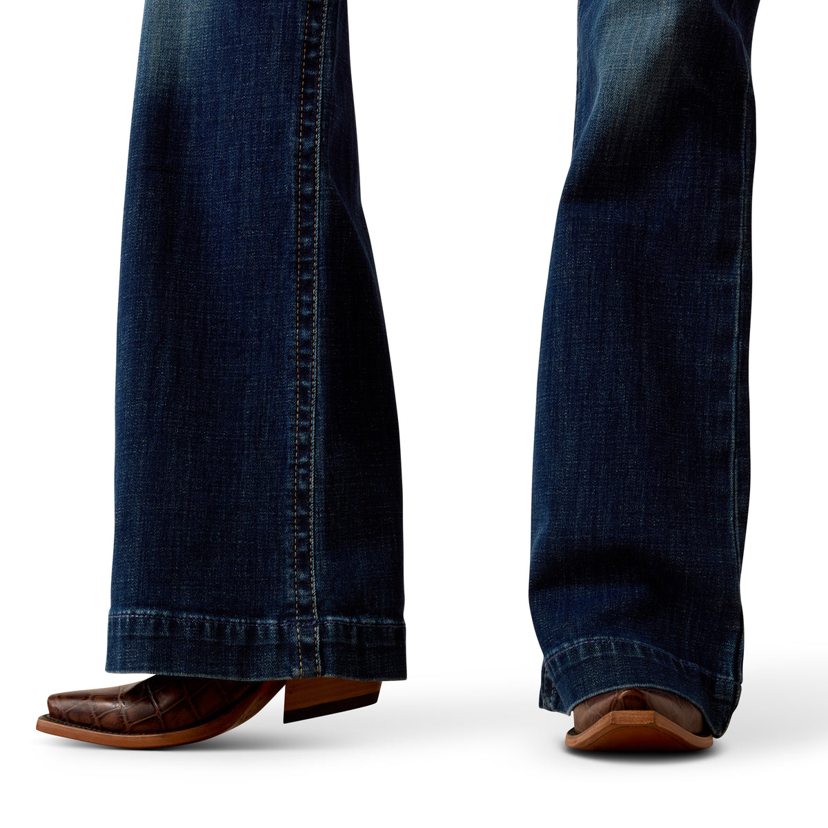 Close-up of blue jeans and brown shoes on a white background