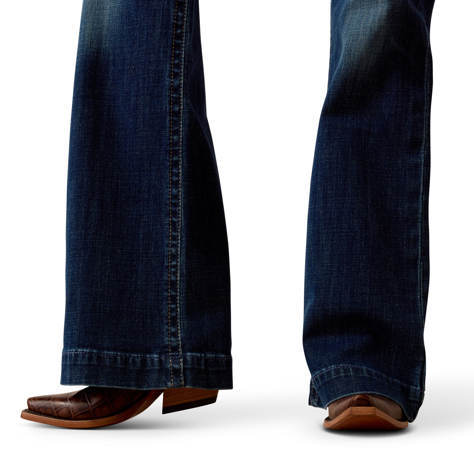 Close-up of blue jeans and brown shoes on a white background