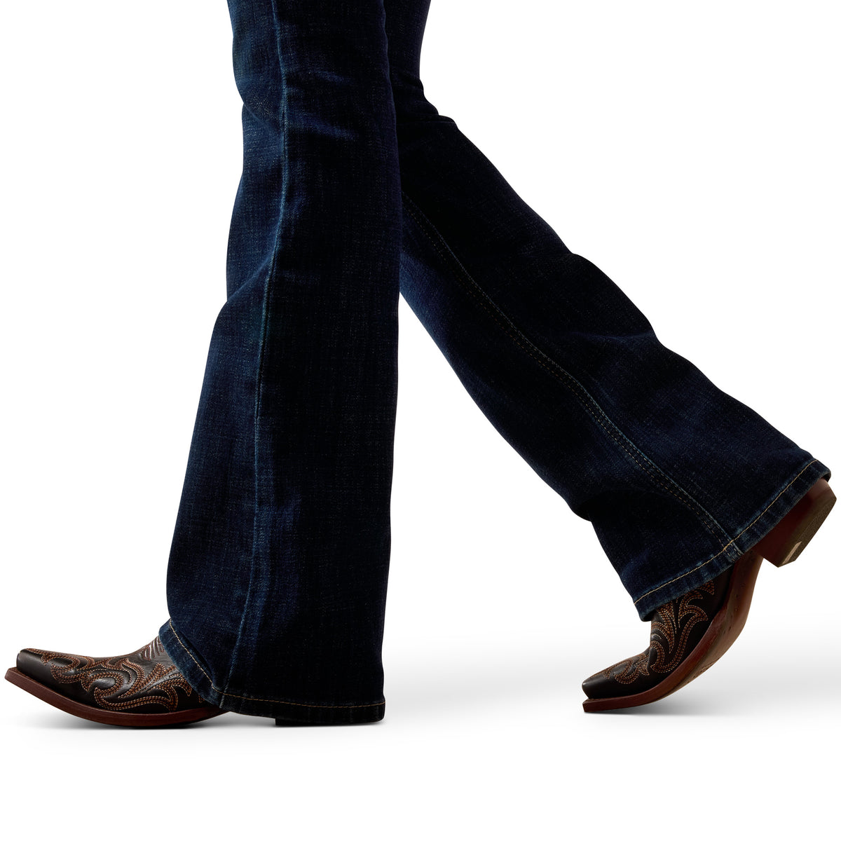 Close-up of legs wearing blue jeans and brown cowboy boots on a white background