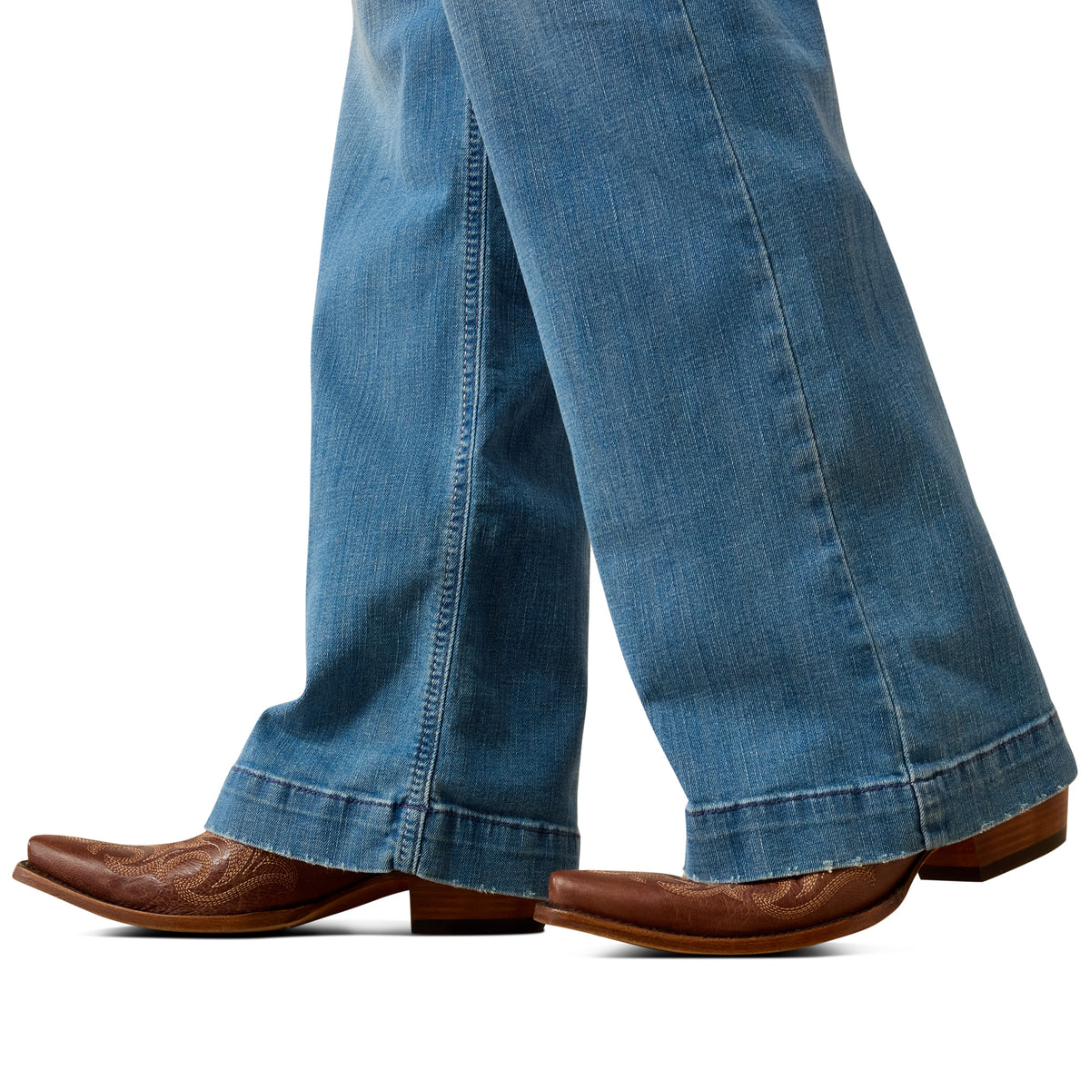 Blue jeans and brown cowboy boots on a white background