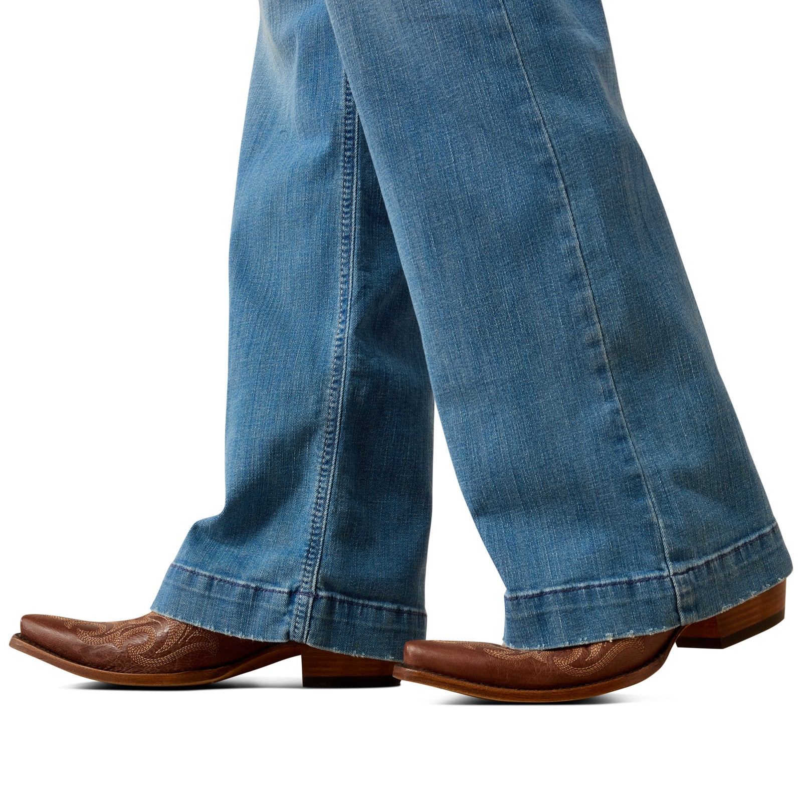 Blue jeans and brown cowboy boots on a white background