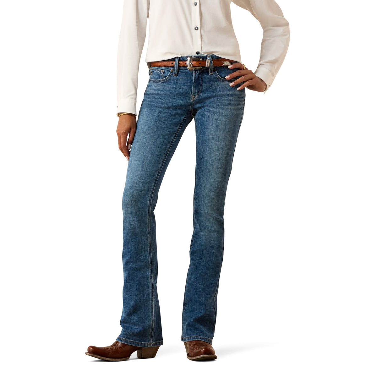 A model wearing a pair of blue western-style jeans with a brown leather belt, paired with a cream button-down shirt and brown cowboy boots, shown from the waist down on a white background.