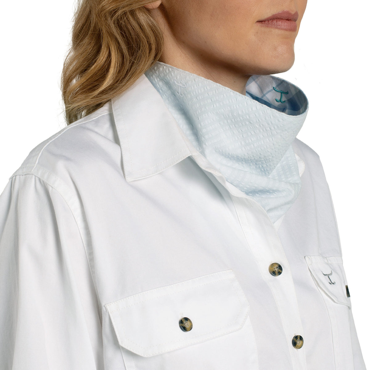 Close-up of a person wearing a white shirt with a collar and buttons.