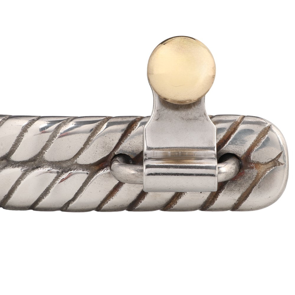 Double Twisted Band Spurs. Close-up of a silver bracelet with a gold clasp on a white background