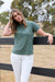 Woman wearing a Thomas Cook Women's Michelle S/S Polo. Khaki polo shirt with a small logo on a white background