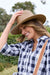 Thomas Cook Abigail Hat. Beige straw hat with a band on a white background