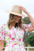 Thomas Cook Abigail Hat. Beige straw hat with a band on a white background
