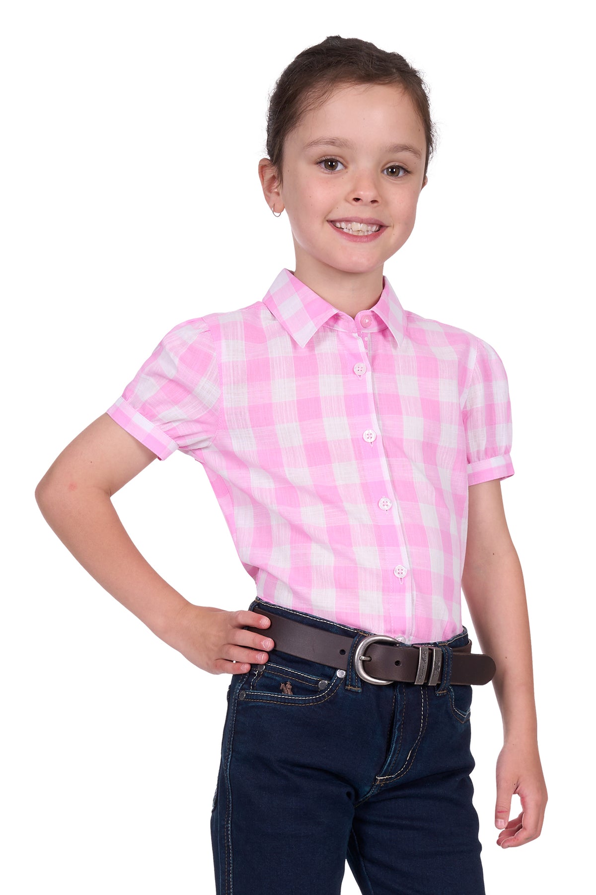 Thomas Cook Girl's Eliza S/S Shirt. Young girl wearing a pink and white checkered shirt with dark jeans on a white background