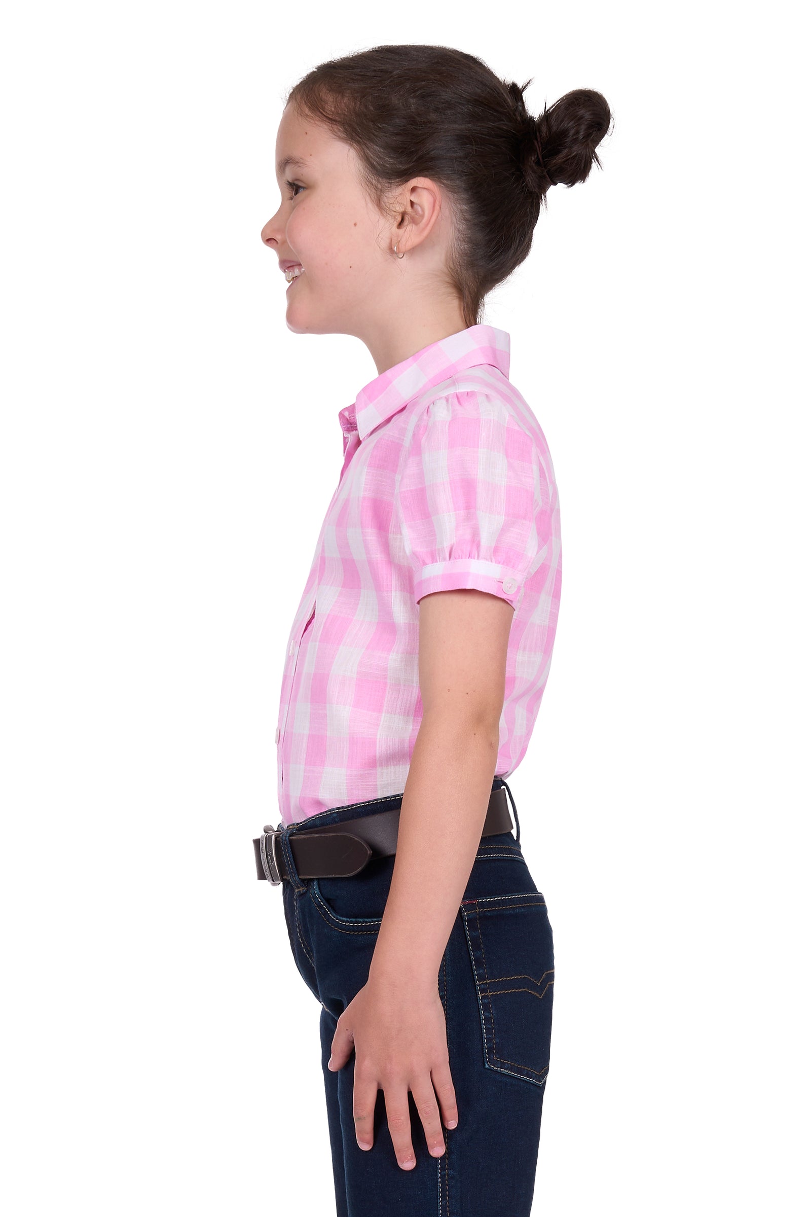 Thomas Cook Girl's Eliza S/S Shirt. Young girl wearing a pink checkered shirt and dark jeans on a white background