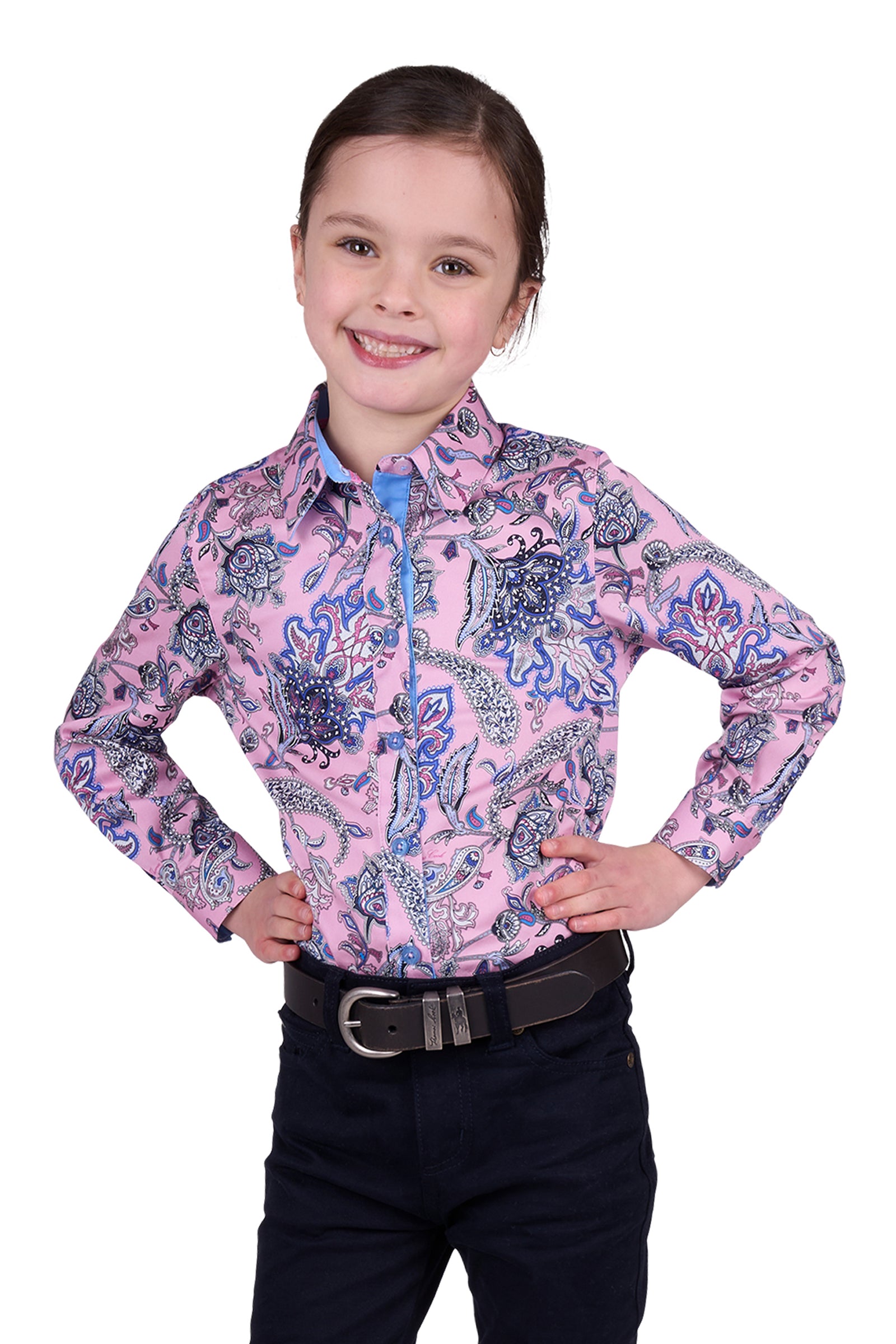 Thomas Cook Girl's Cindy L/S Western Shirt. A girl wearing a long sleeve floral western shirt in pink with a collar and buttons, paired with dark pants.