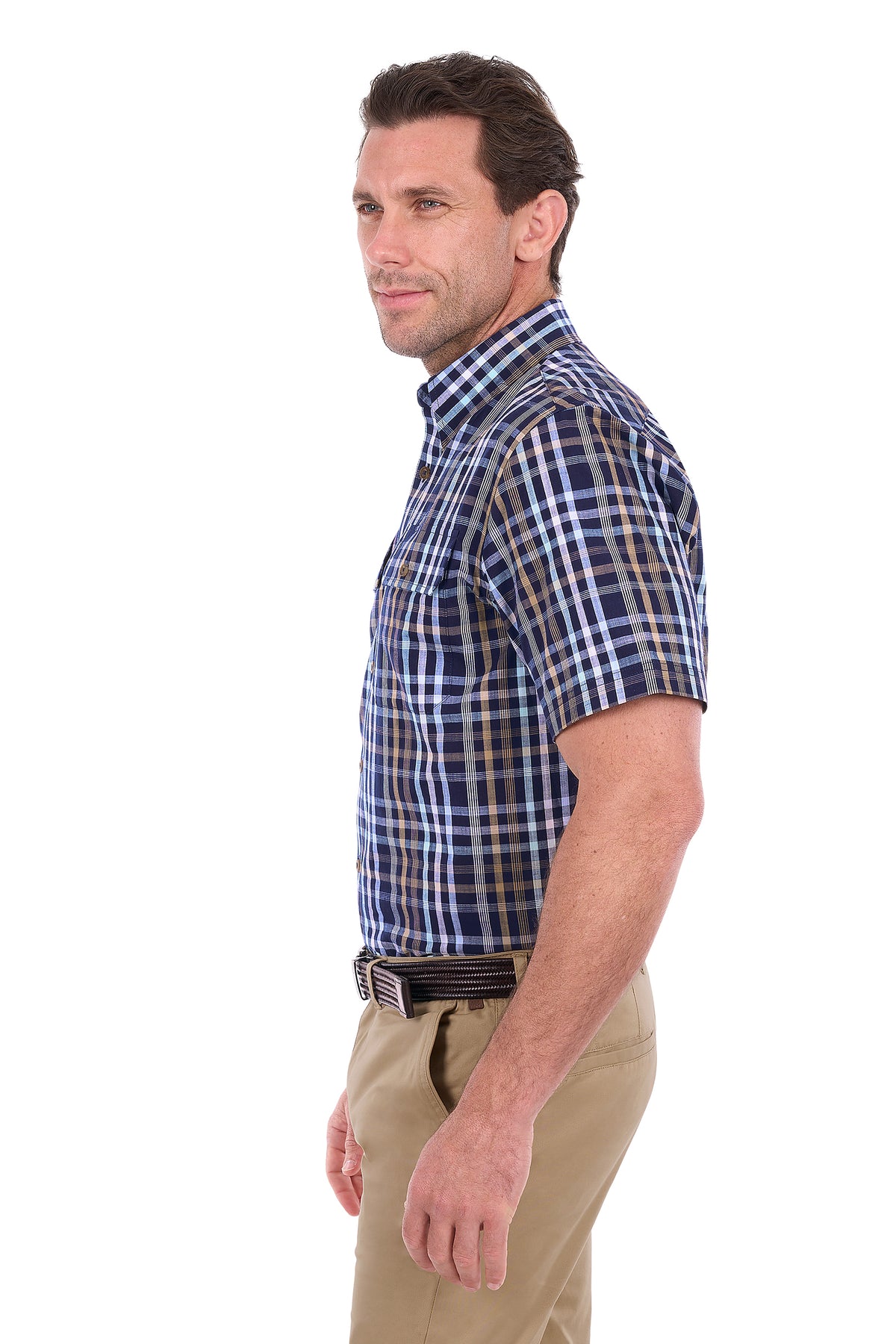 A man shown in profile wearing a short-sleeve button-down plaid shirt in blue, white, and brown, paired with khaki pants, against a plain white background.
