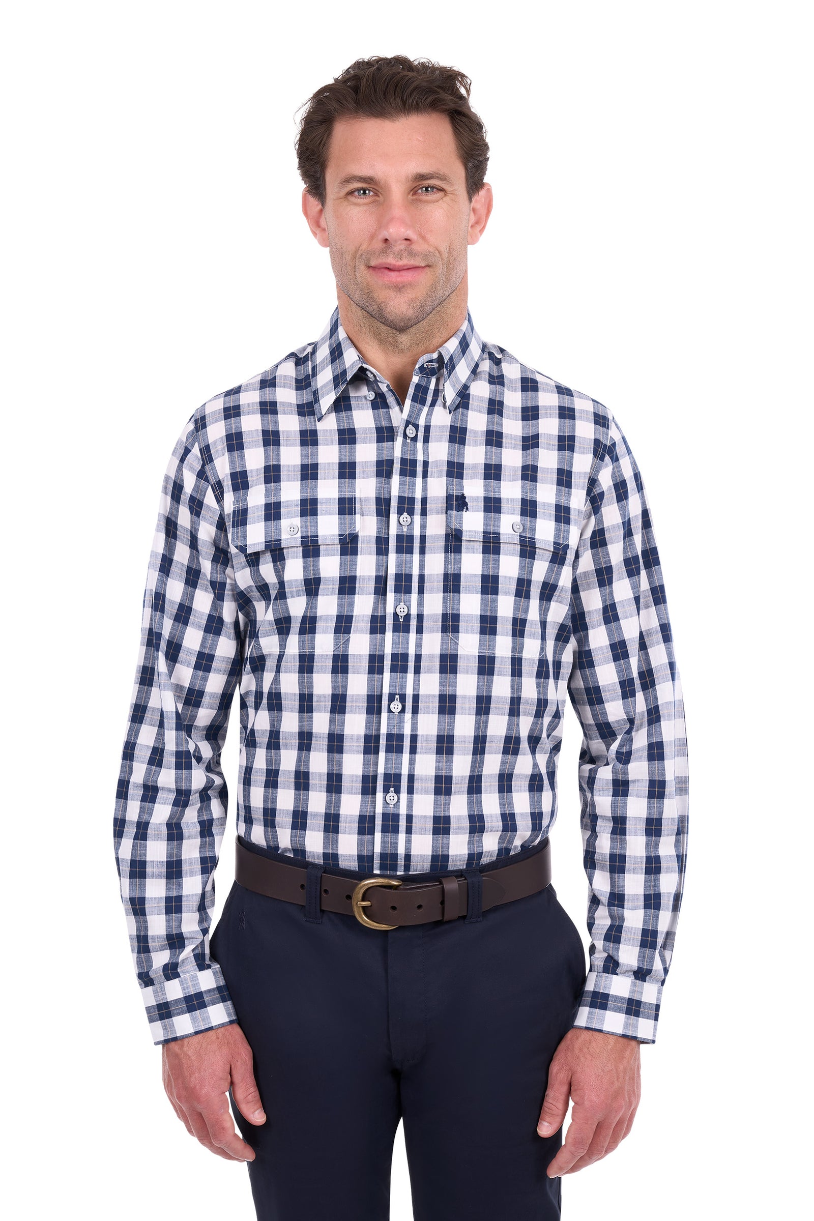 A man wearing a long-sleeve button-down shirt with a navy and white gingham check pattern, paired with dark trousers and a brown belt, standing against a plain white background.