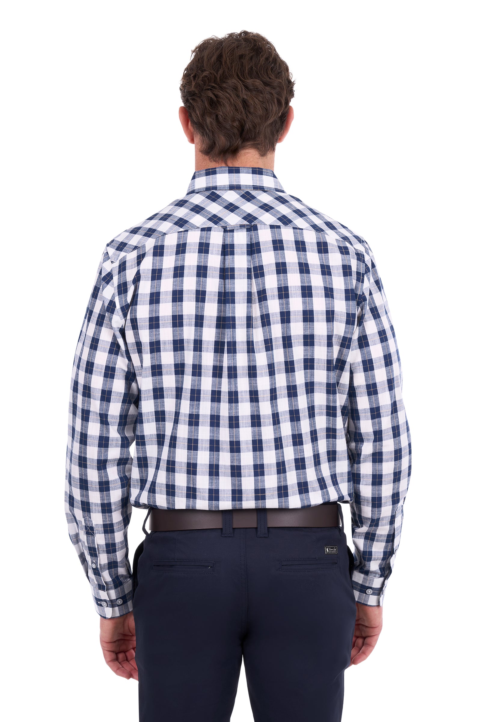 A man viewed from behind wearing a navy and white gingham check long-sleeve button-down shirt, paired with dark navy trousers and a dark belt, against a plain white background.