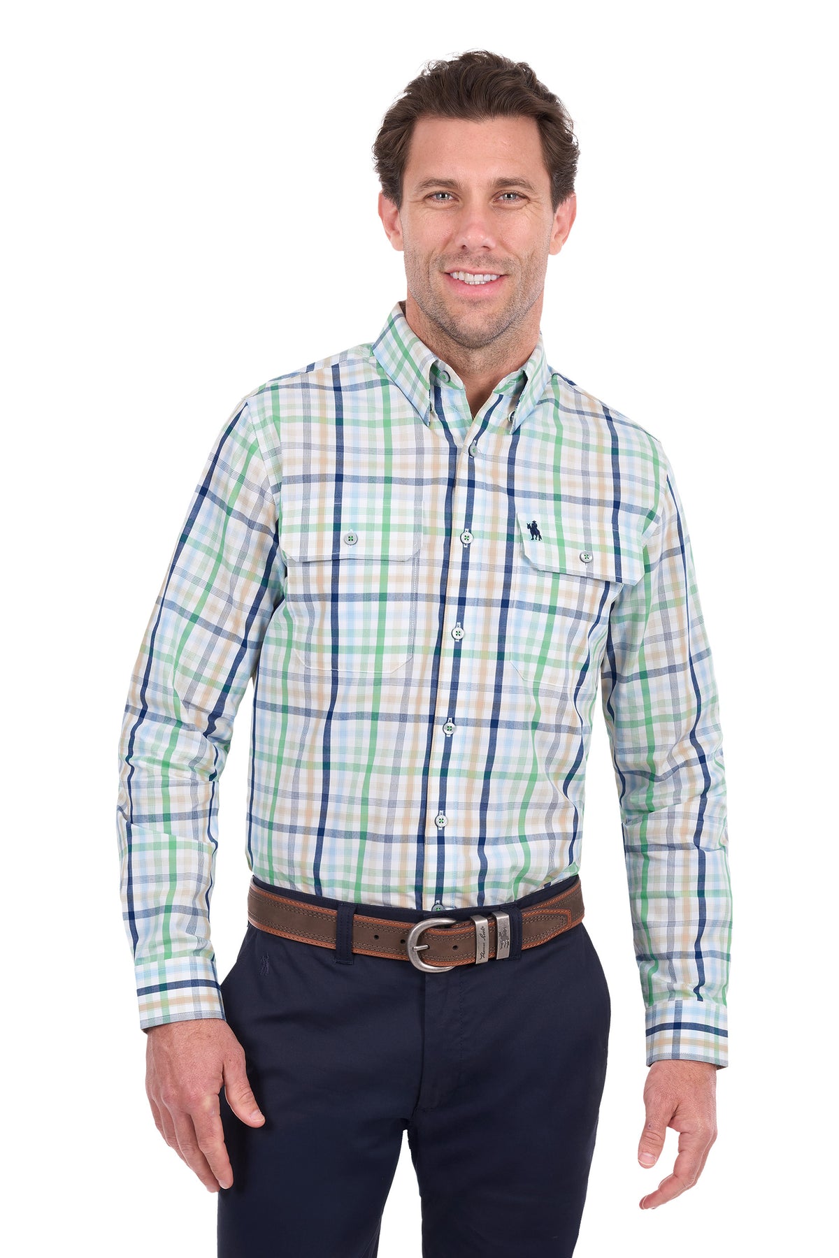 A man wearing a long-sleeve button-down plaid shirt in green, blue, and white, paired with dark navy pants and a brown belt, against a plain white background.