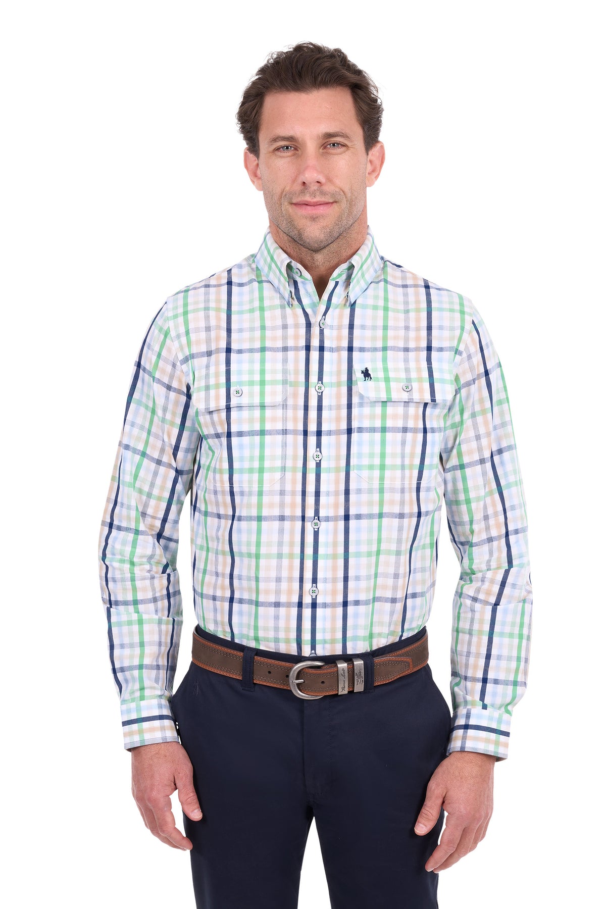 A man modeling a long-sleeve button-down plaid shirt with green, blue, and white lines on a white background, paired with dark navy pants and a brown belt.