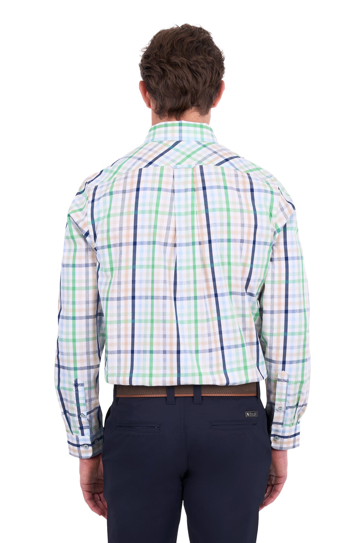 A man viewed from the back wearing a long-sleeve plaid button-down shirt with green, blue, and white stripes on a white base, paired with dark navy trousers.