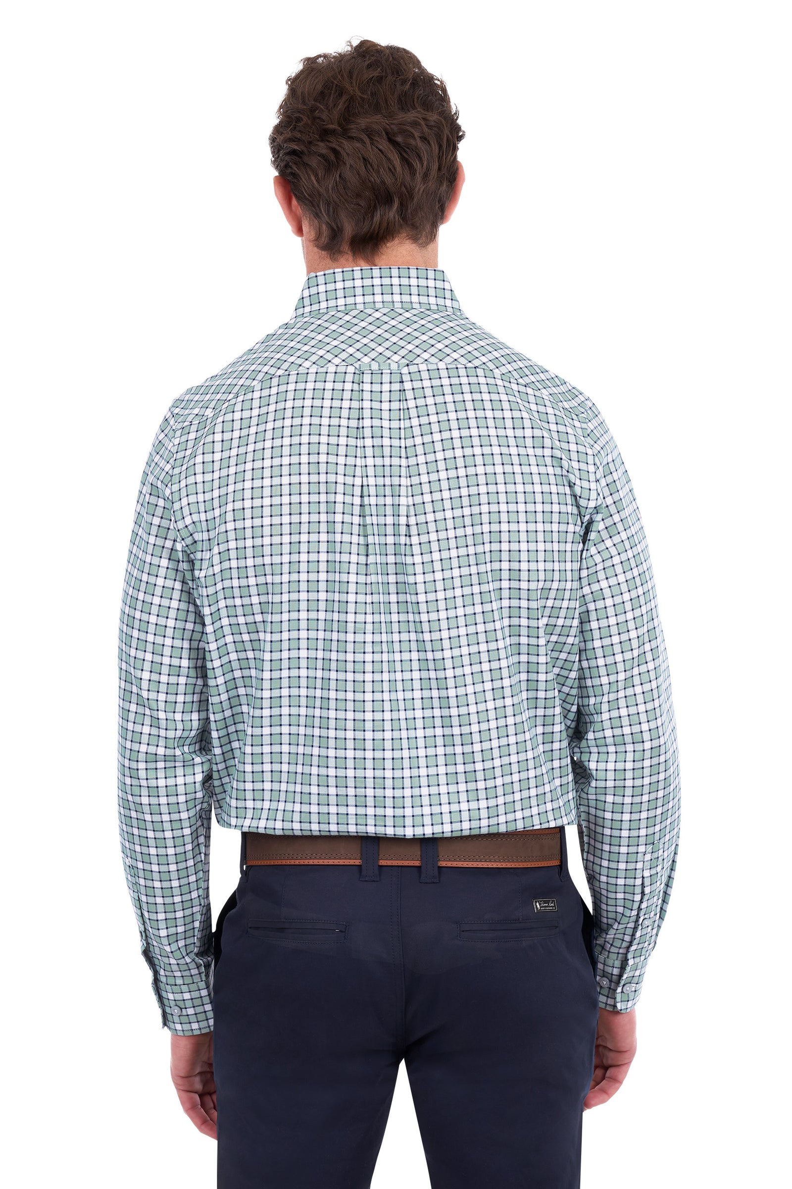 A man viewed from behind wearing a long-sleeve button-down shirt with a green and white windowpane plaid pattern, paired with navy blue trousers and a brown belt, against a solid white background.