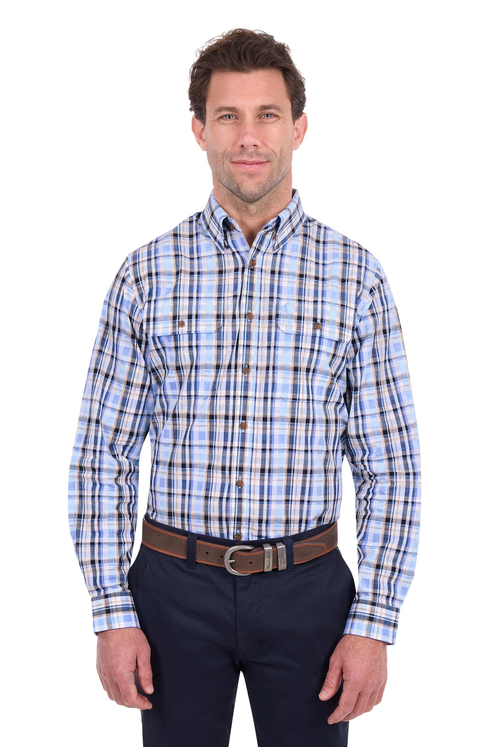 A man wearing a long-sleeve button-down plaid shirt in shades of blue, white, and black, paired with dark navy pants and a brown belt, against a plain white background.