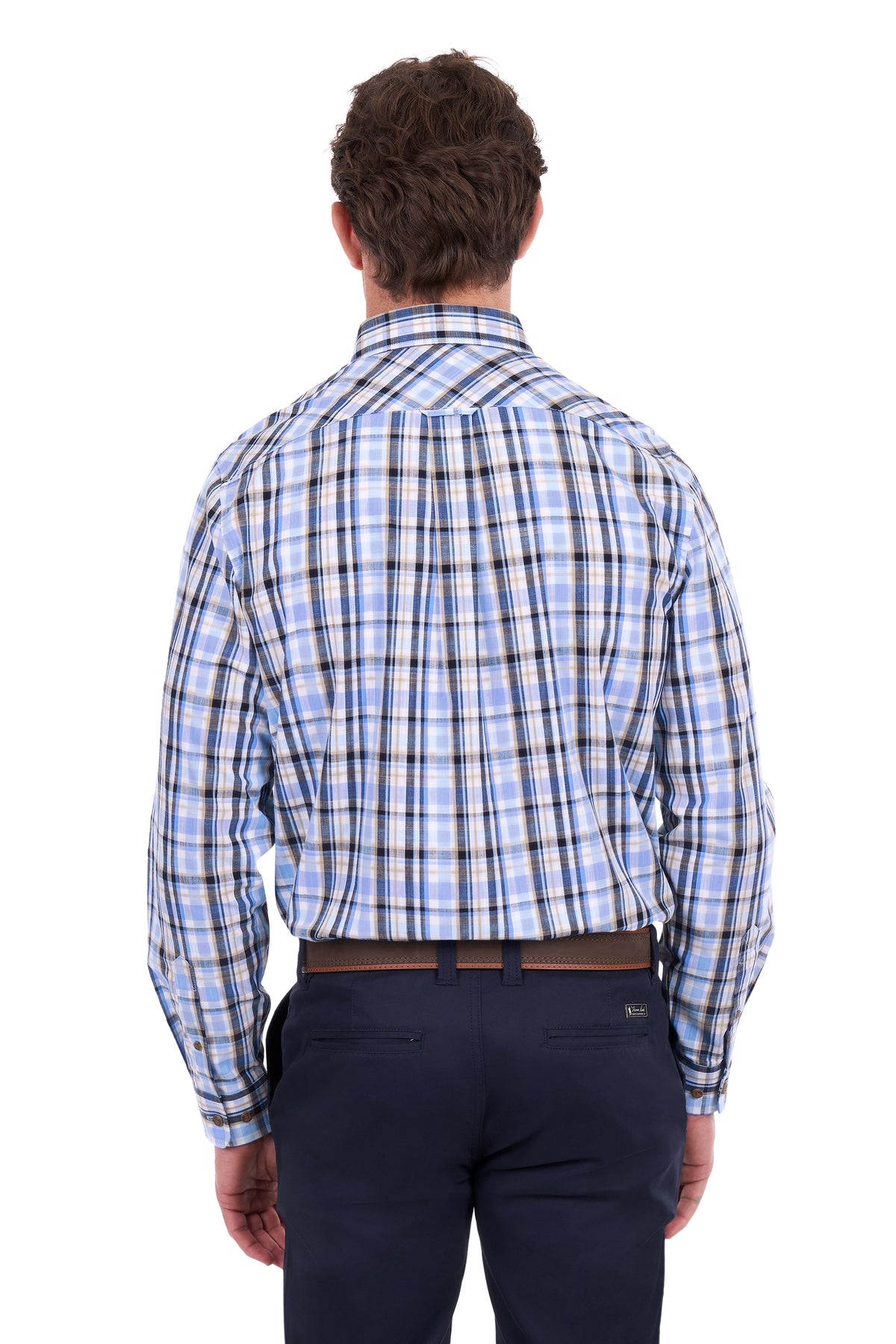 A man viewed from behind wearing a light blue, white, and black plaid button-down shirt, paired with dark navy trousers and a brown belt, against a plain white background.