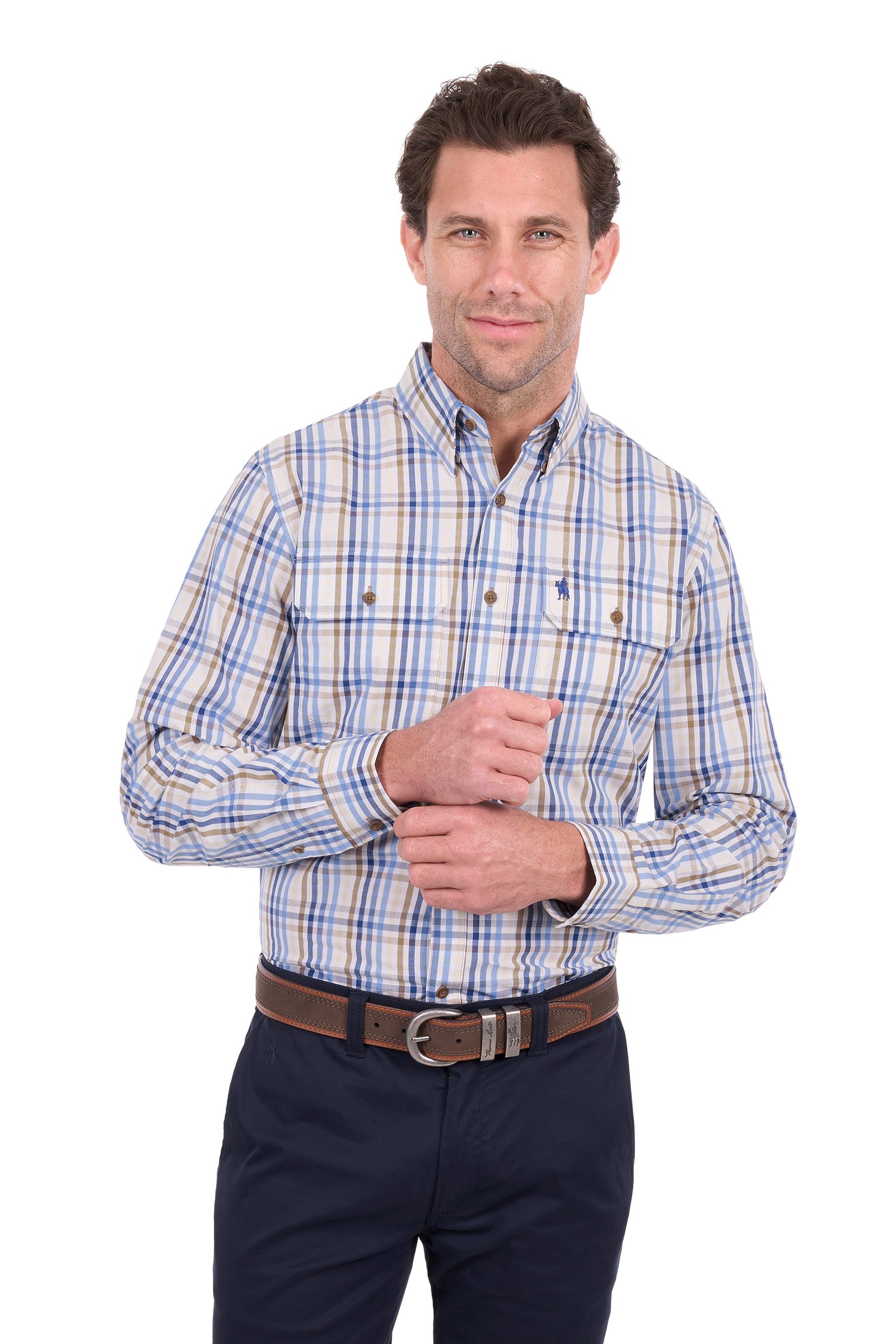 A man wearing a long-sleeve button-down plaid shirt with blue, yellow, and white stripes, paired with dark navy pants and a brown belt, against a plain white background.
