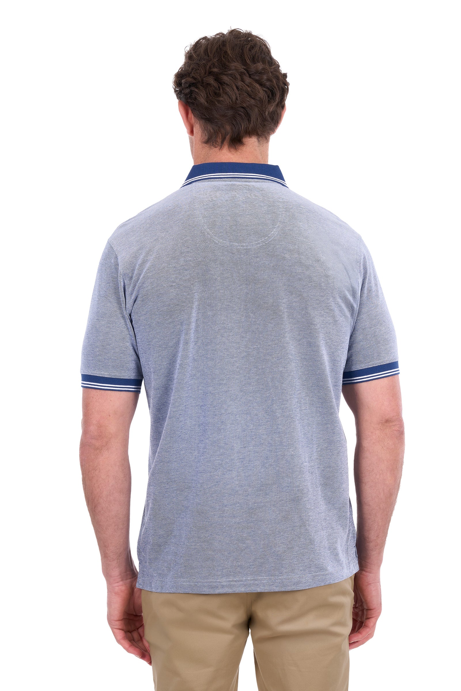 A man viewed from the back wearing a light heather gray polo shirt with navy blue collar and sleeve trim, paired with khaki pants, against a plain white background.