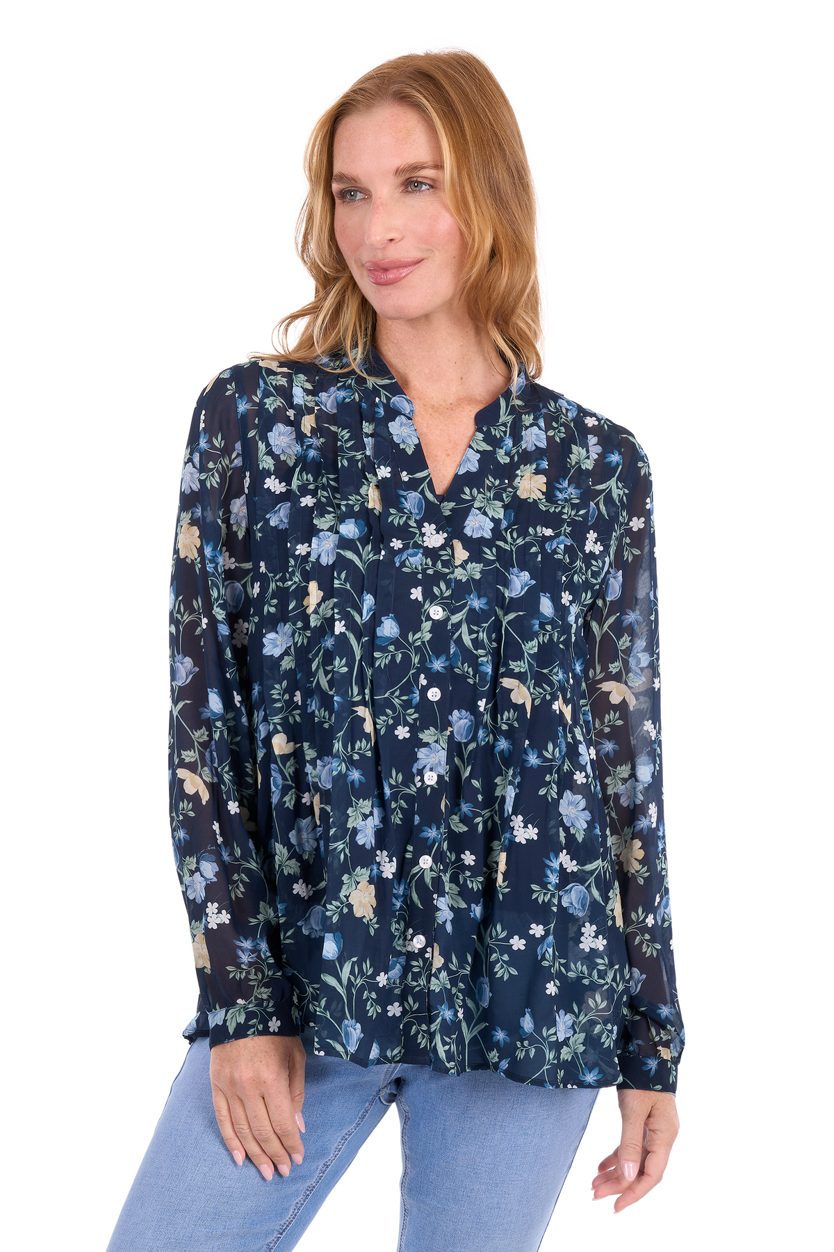 A woman wearing a navy blue long-sleeve blouse with a light blue, white, and beige floral pattern, paired with light blue jeans, against a plain white background.