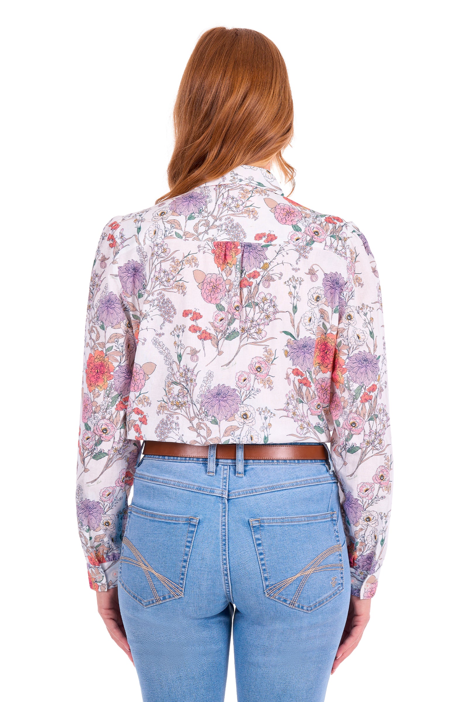 A woman viewed from the back wearing a long-sleeve floral print blouse with a butterfly motif and light blue jeans, against a plain white background.