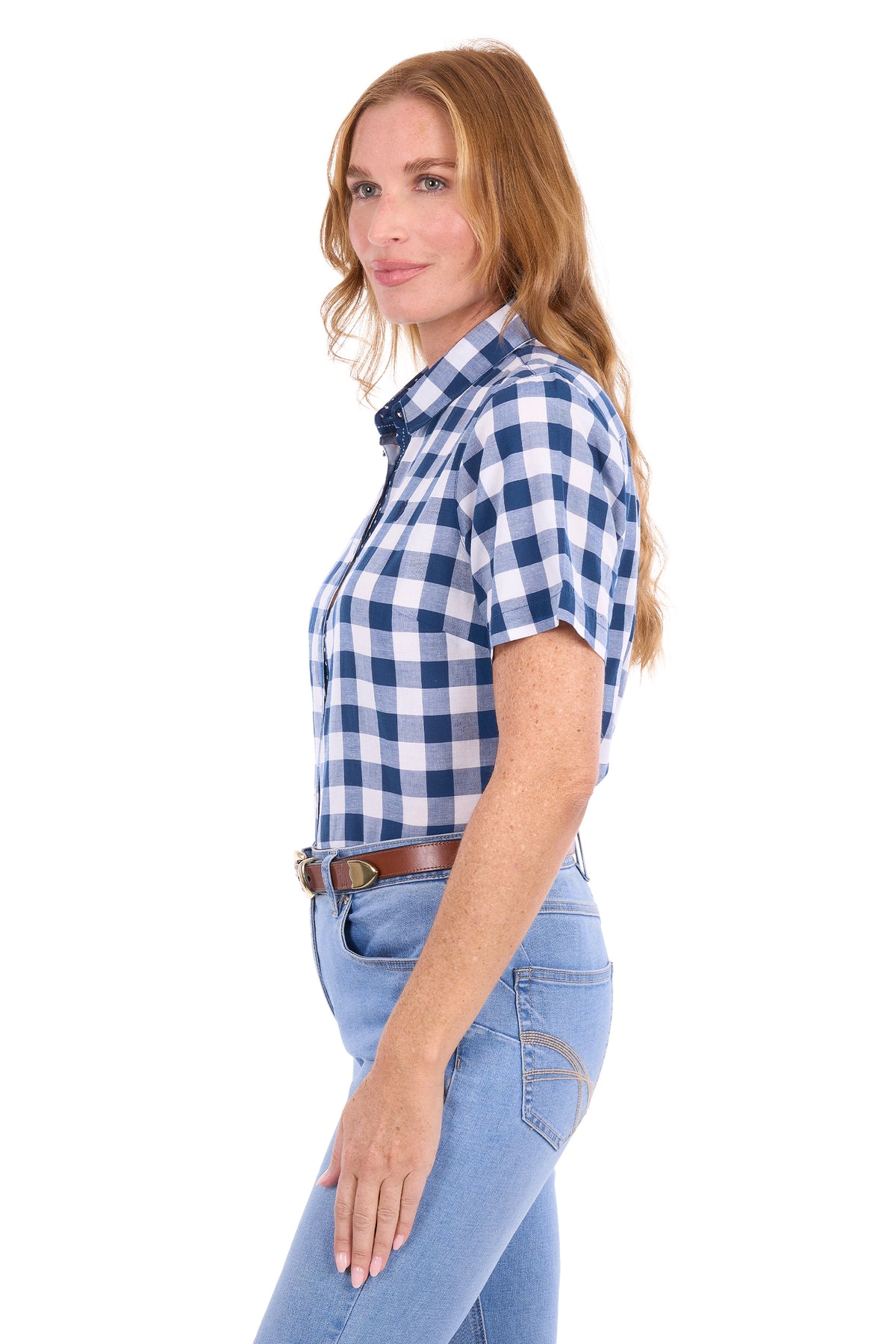 A woman wearing a blue and white gingham short-sleeve button-up shirt with light blue jeans, shown in profile against a plain white background.