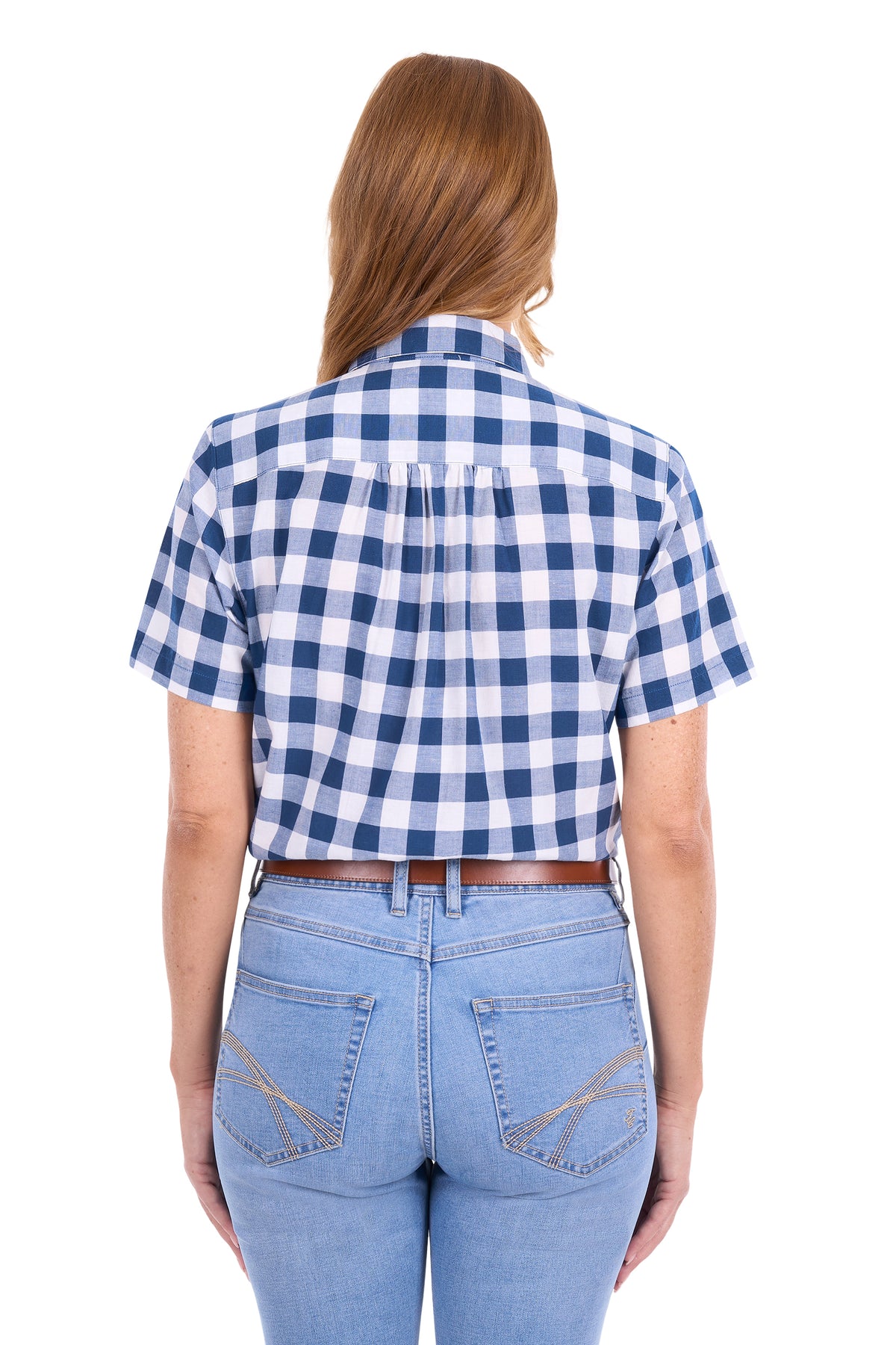 A woman viewed from the back wearing a short-sleeve blue and white gingham check shirt tucked into light-wash blue jeans with a brown belt, against a plain white background.