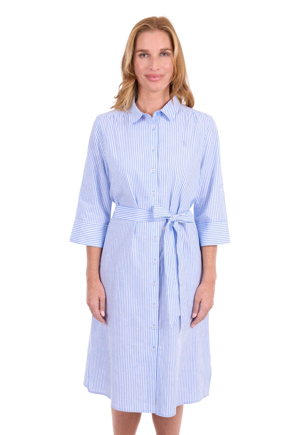 A woman modeling a light blue and white vertically striped shirt dress with a tie waist and three-quarter sleeves, set against a plain white background.
