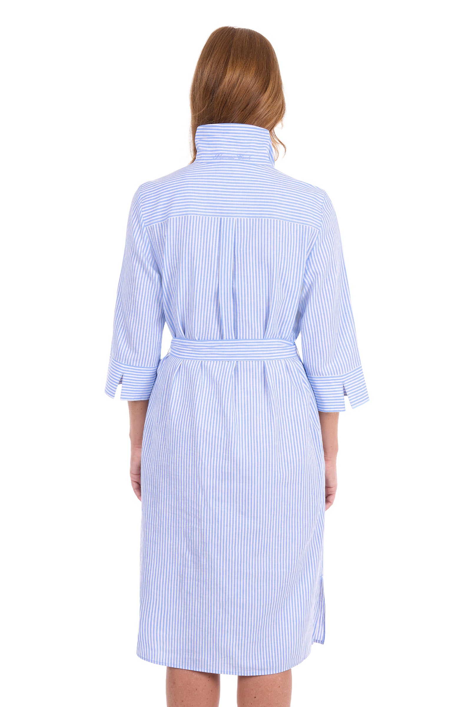 A woman viewed from the back wearing a light blue and white vertically striped bathrobe with a high collar and three-quarter sleeves, set against a plain white background.