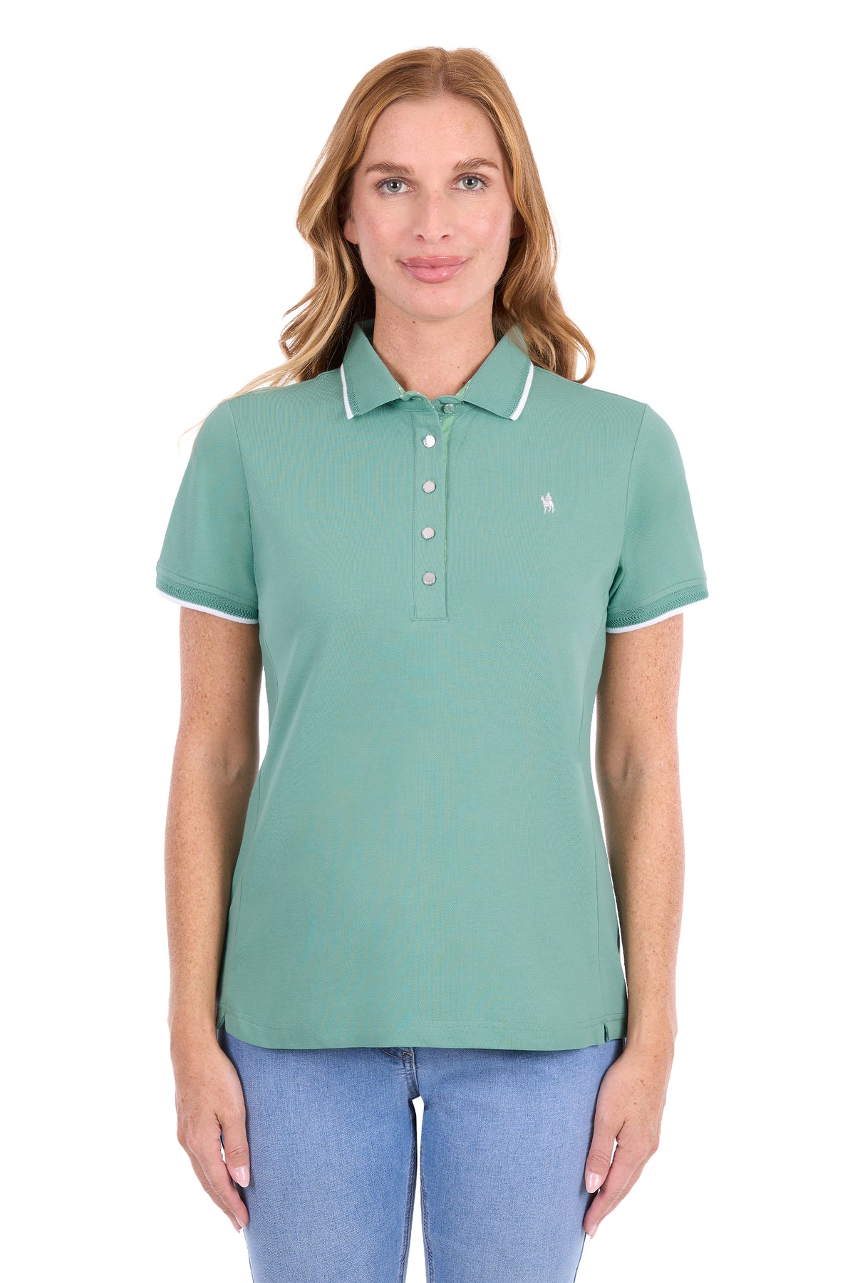 A woman modeling a sage green short-sleeve polo shirt with white contrast piping on the collar and sleeve cuffs, paired with blue jeans against a plain white background.