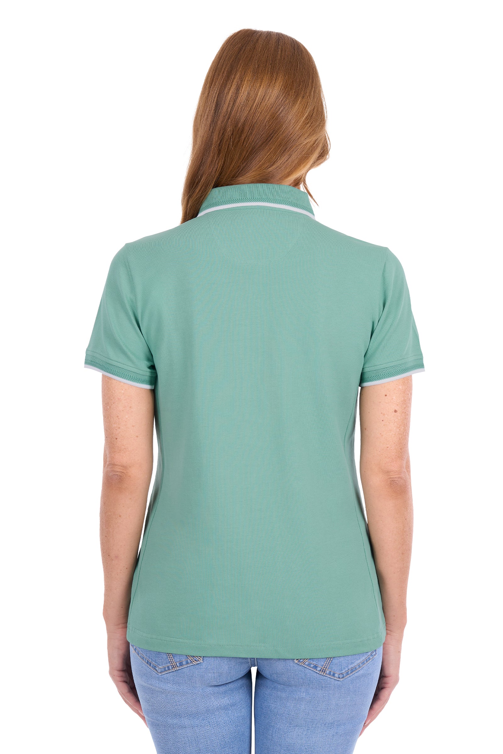 A woman viewed from the back wearing a sage green short-sleeve polo shirt with white piping on the collar and sleeve cuffs, paired with light blue jeans against a plain white background.