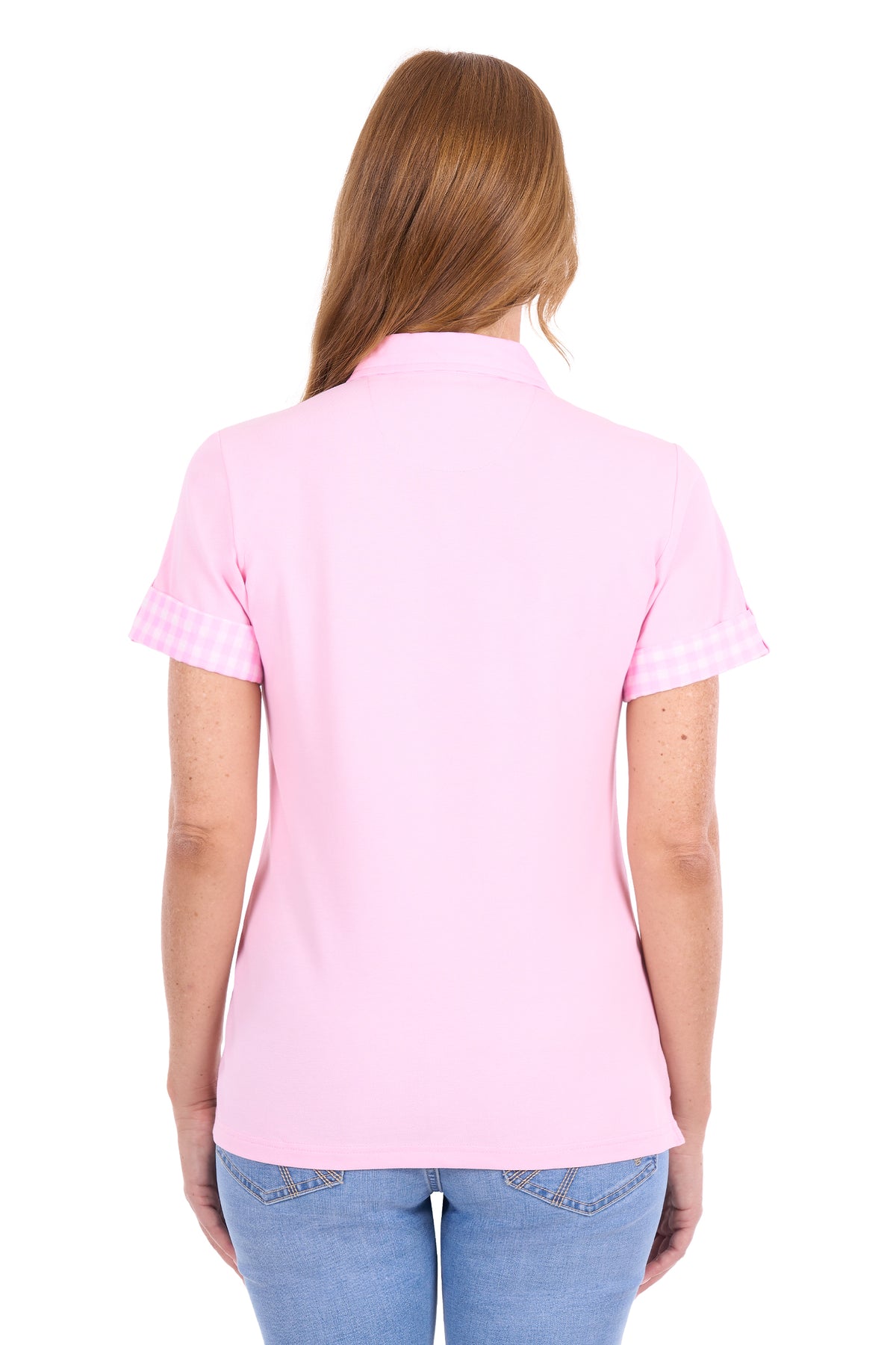 A woman viewed from the back wearing a light pink short-sleeve polo shirt with a subtle gingham check pattern on the sleeve cuffs, paired with blue jeans against a plain white background.