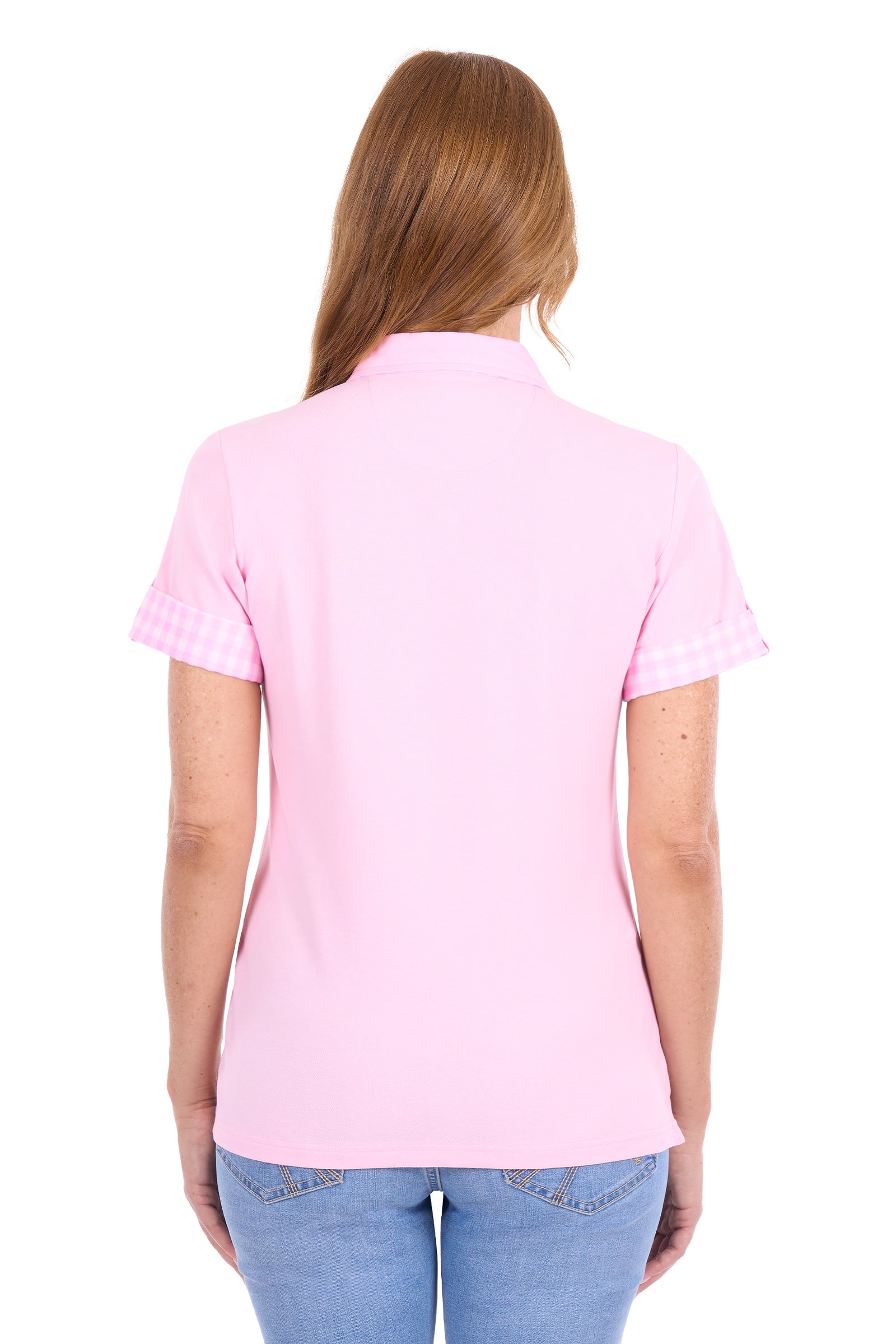 A woman viewed from the back wearing a light pink short-sleeve polo shirt with a subtle gingham check pattern on the sleeve cuffs, paired with blue jeans against a plain white background.