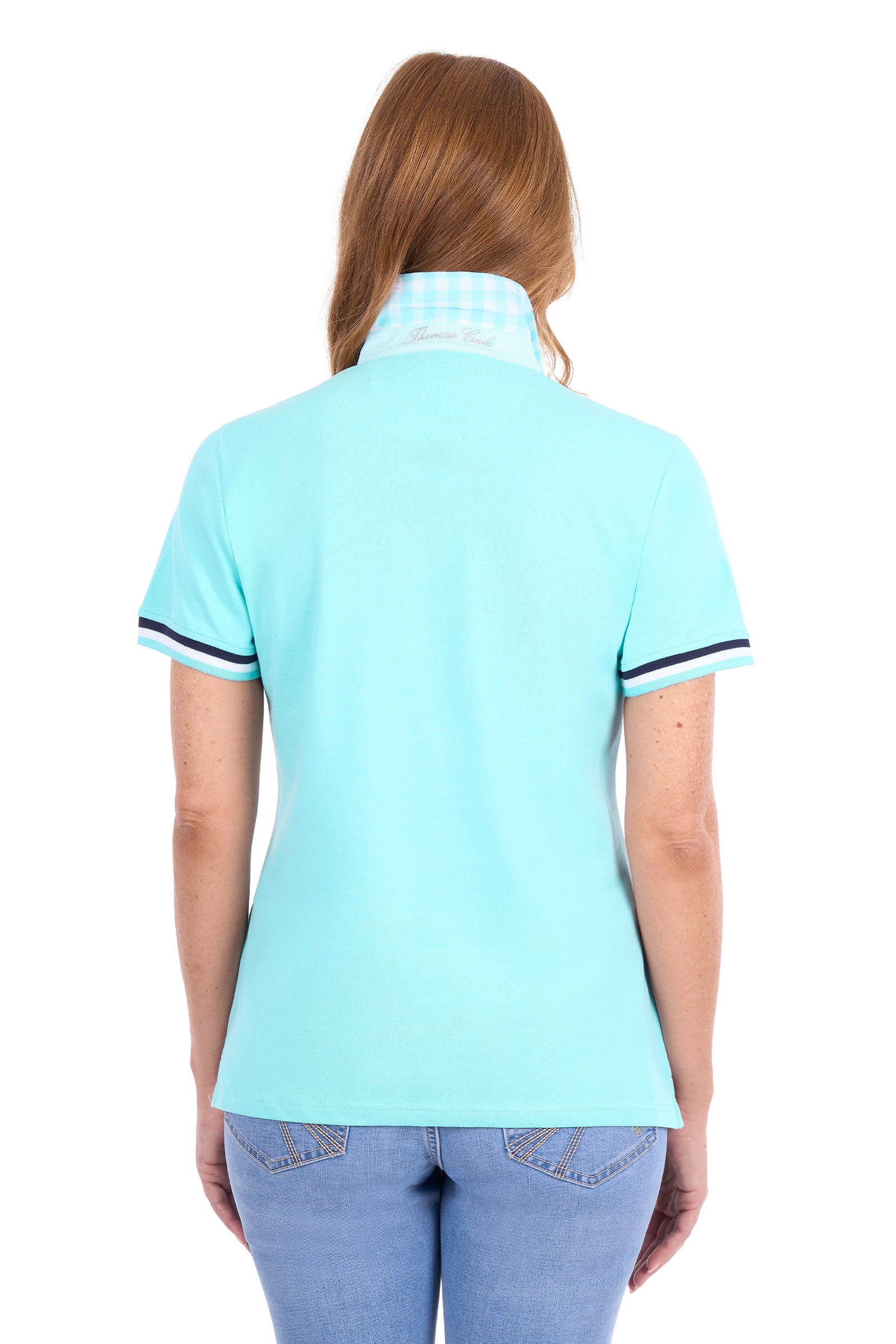 A woman viewed from the back wearing a light aqua short-sleeve polo shirt with a white and blue gingham patterned collar and navy trim on the sleeve cuffs, paired with light blue jeans against a white background.