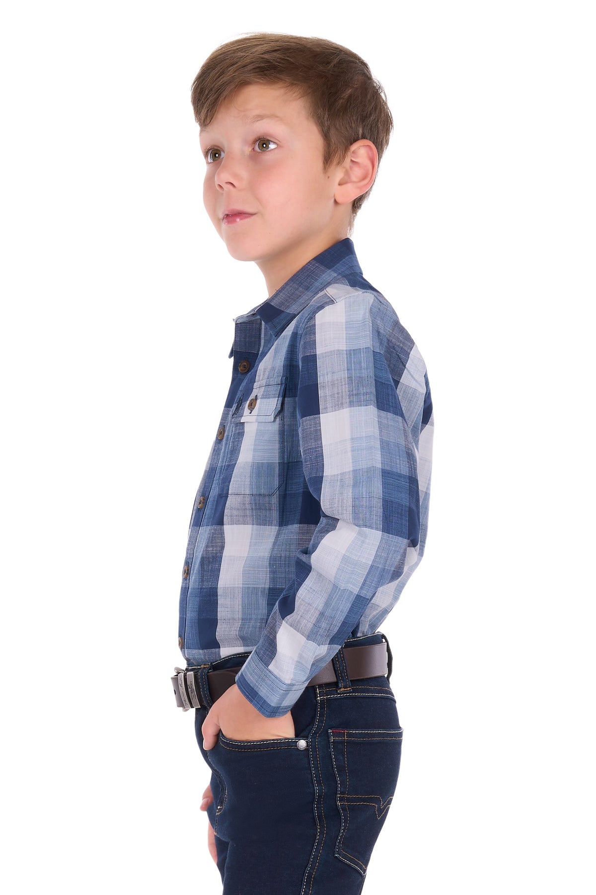 A young boy in profile wearing a blue and white plaid long-sleeve button-up shirt and dark blue jeans, photographed against a solid white background.