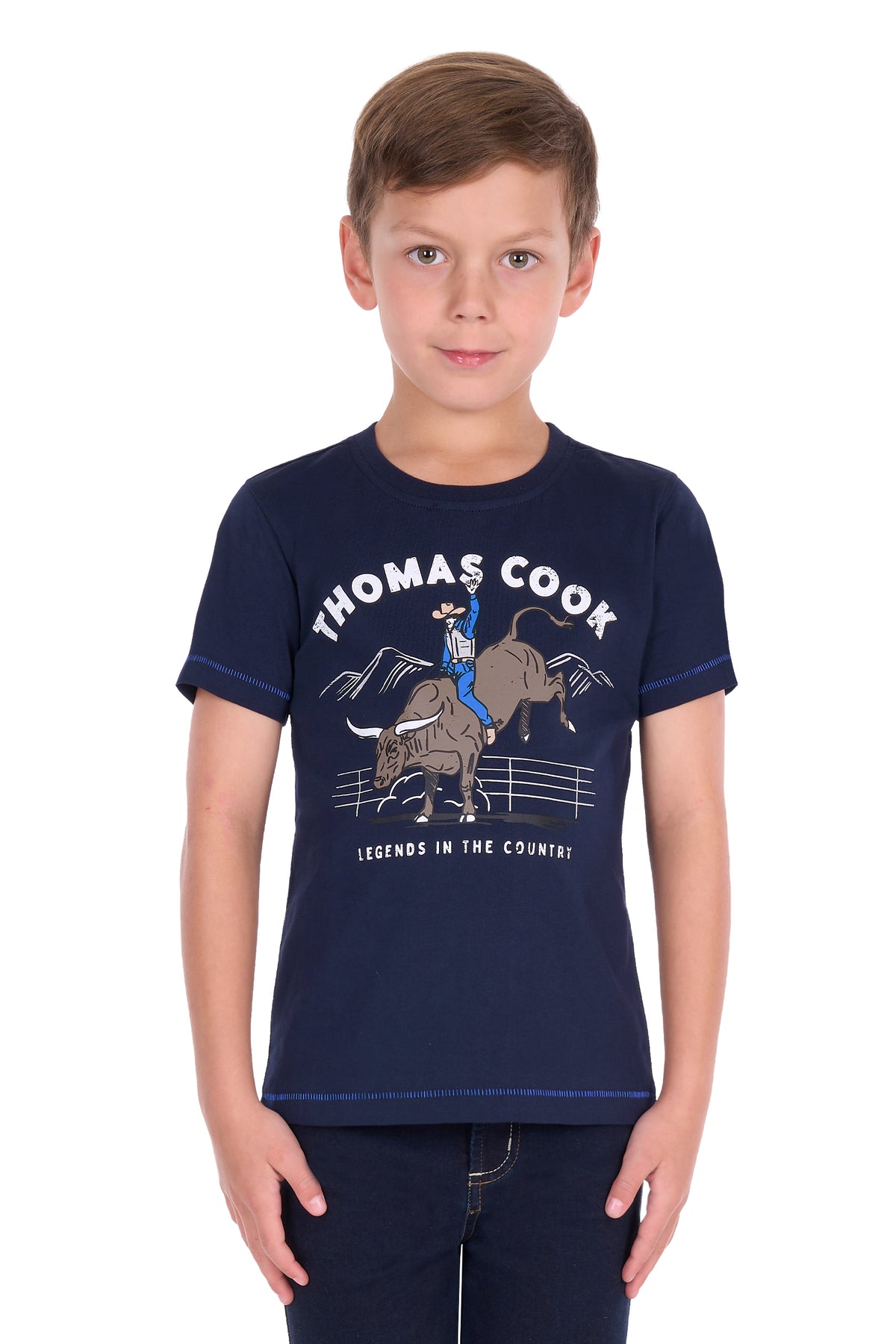 A young boy wearing a navy blue short-sleeve t-shirt with a western-themed graphic print that reads 'THOMAS COOK' and 'LEGENDS IN THE COUNTRYS', paired with dark jeans, set against a plain white background.