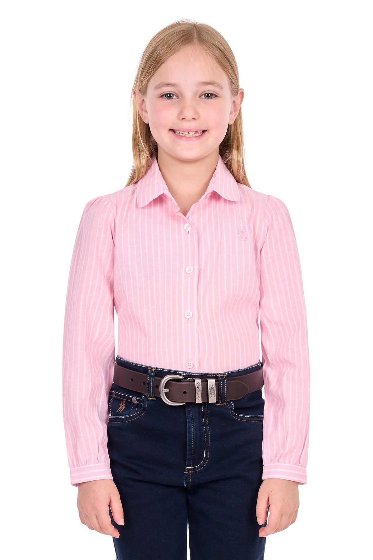 A young girl with blonde hair wearing a pink and white vertically striped long-sleeve button-down shirt, a brown belt, and dark blue jeans, standing against a solid white background.