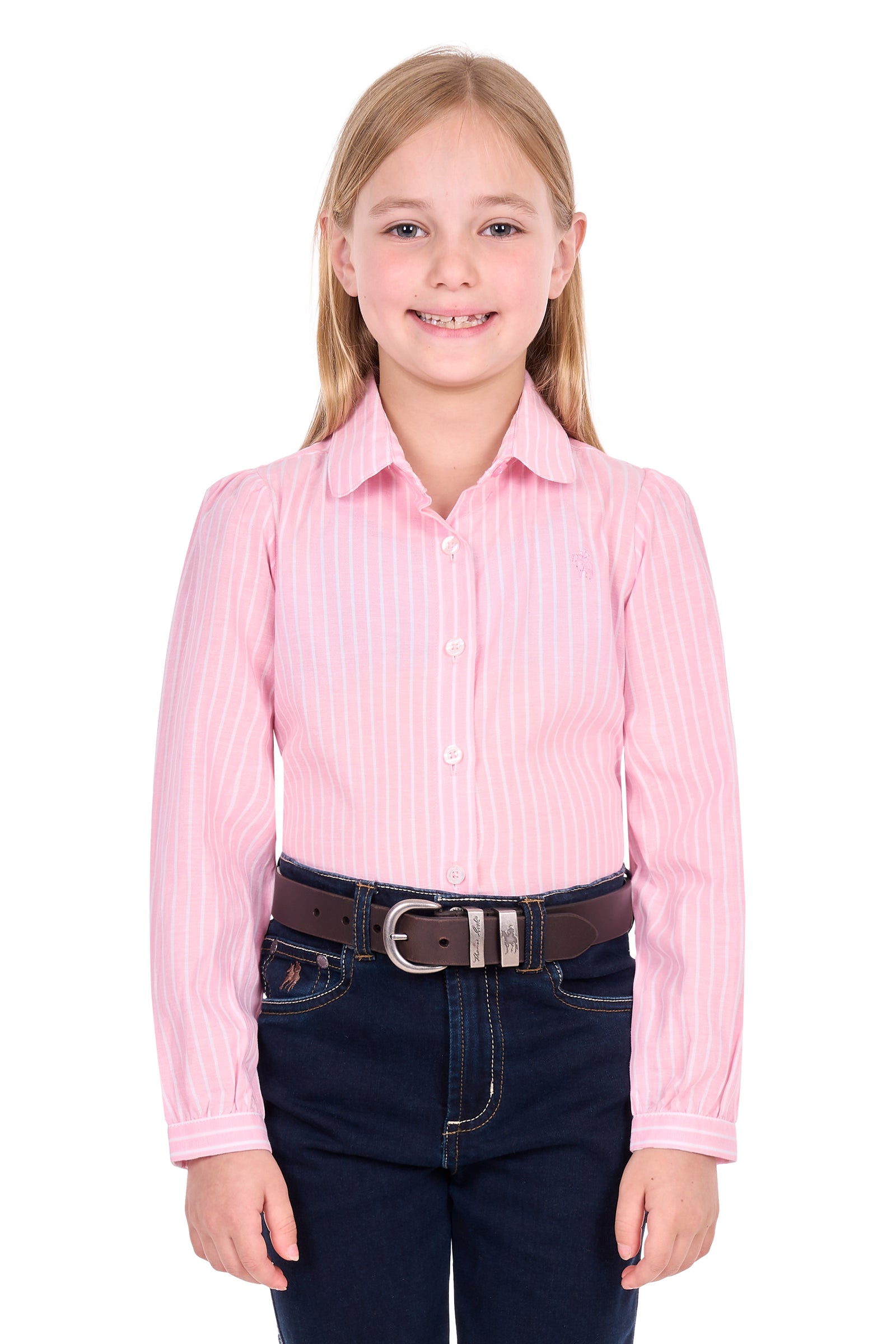 A young girl with blonde hair wearing a pink and white vertically striped long-sleeve button-down shirt, a brown belt, and dark blue jeans, standing against a solid white background.