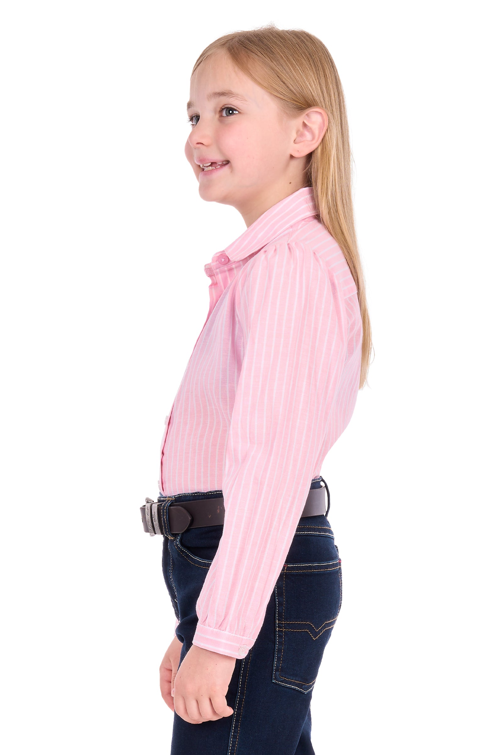 A young girl with long blonde hair is shown in profile wearing a pink and white vertically striped long-sleeve button-down shirt, dark blue jeans, and a black belt, against a solid white background.