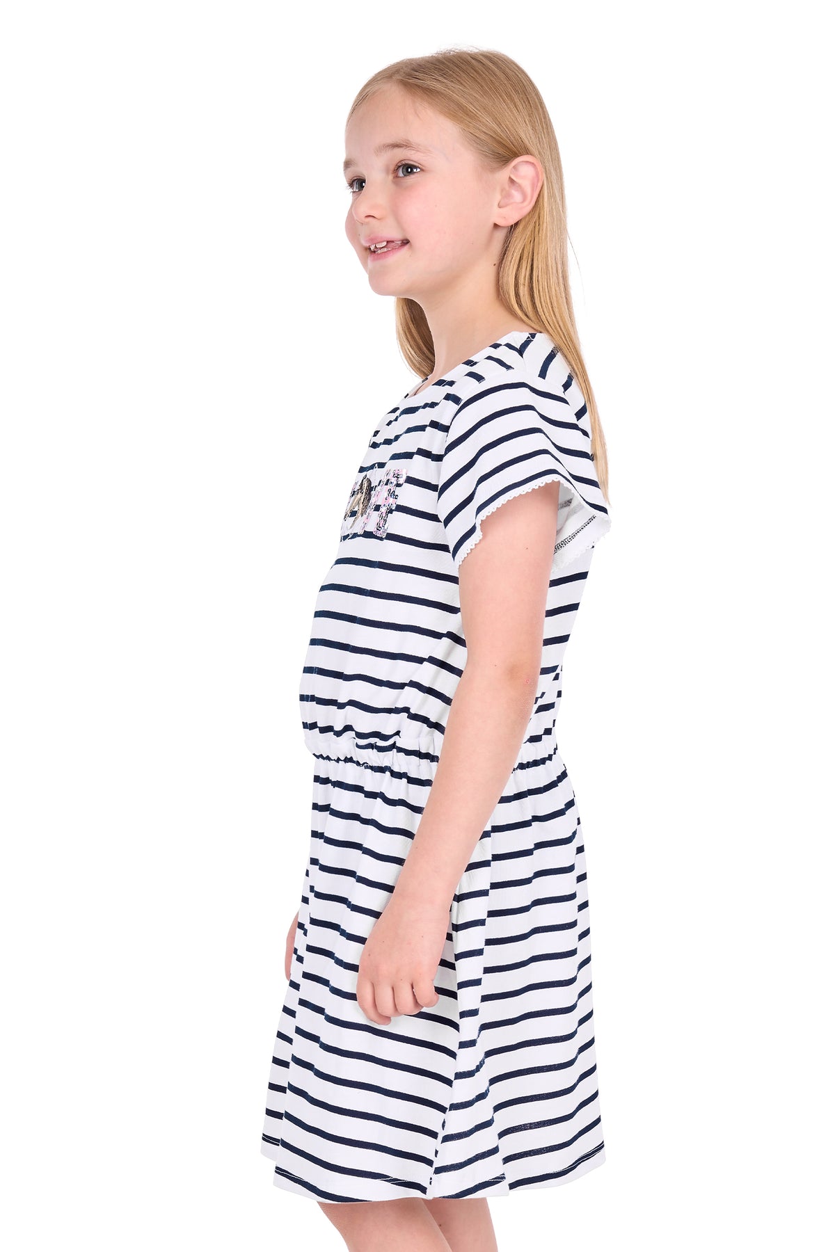 A young girl with blonde hair is wearing a short-sleeve navy and white striped dress, shown from a side profile against a plain white background.
