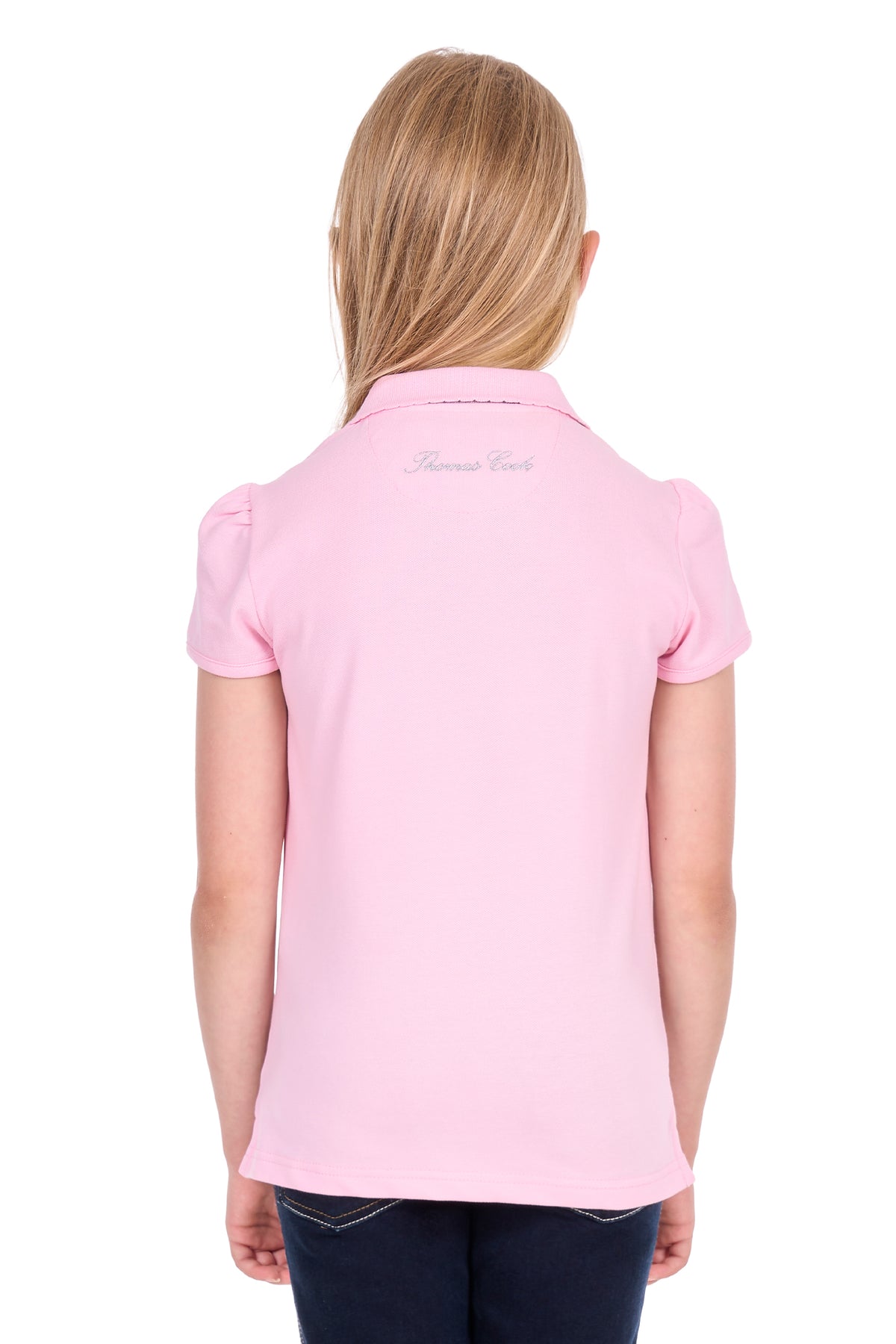 A young girl viewed from the back wearing a light pink short-sleeve polo shirt with 'Hennessy Paris' embroidered in silver on the collar, paired with dark blue jeans against a white background.