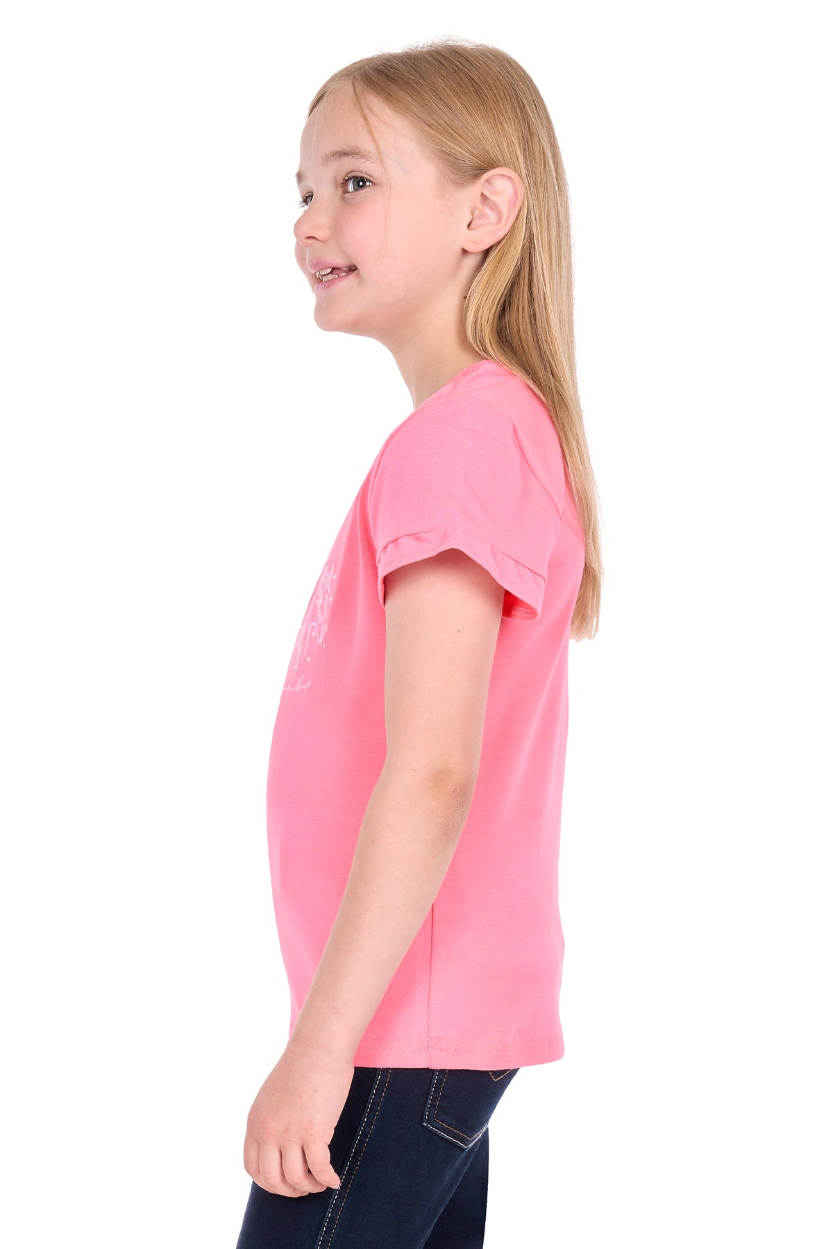 A young girl with blonde hair is shown in profile wearing a short-sleeve pink t-shirt and dark blue jeans against a solid white background.